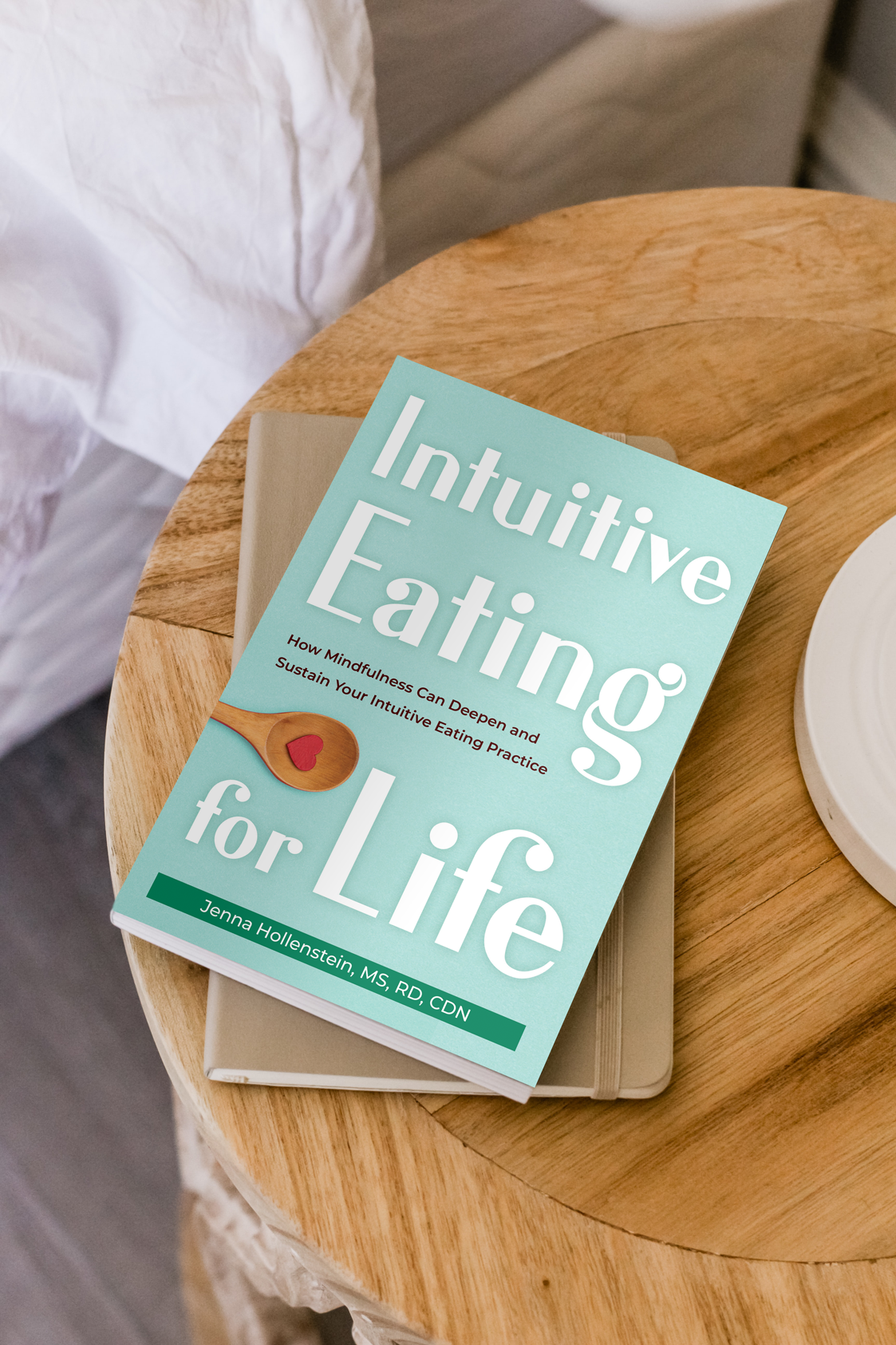 Intuitive Eating for Life book on a nightstand table next to a bed