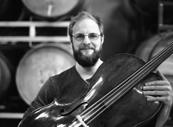 Steuart Pincombe holding his cello in front of him