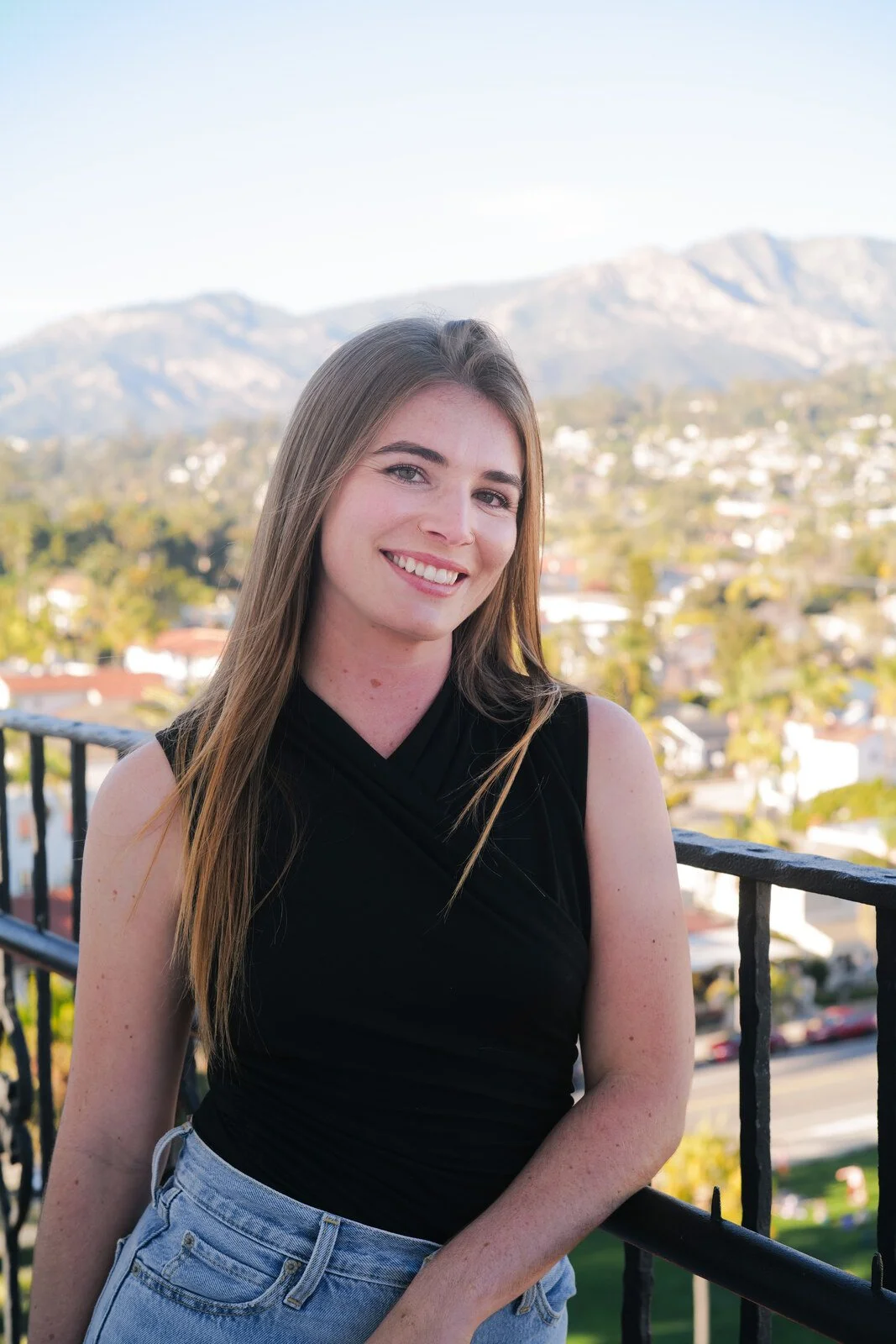 Zoe Maritorena, associate marriage and family therapist, smiling in a black top with Santa Barbara hills in the background