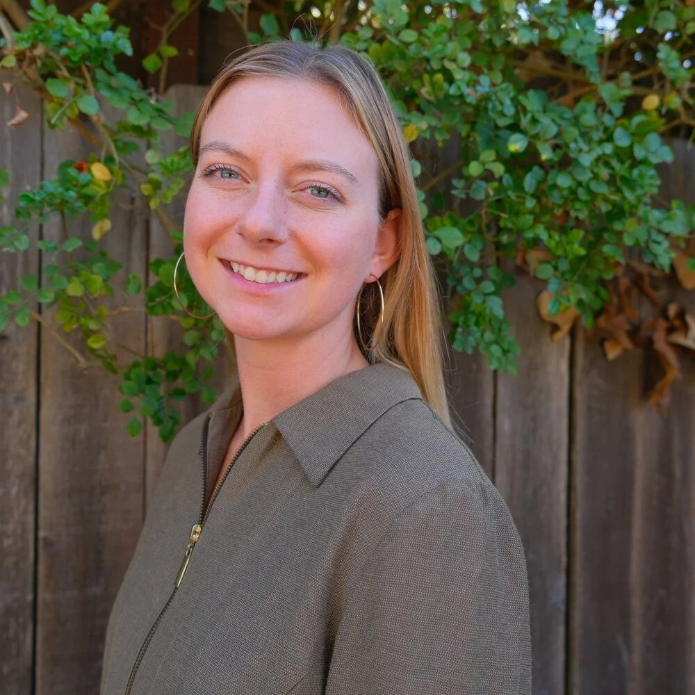 Sarah Dill, associate marriage and family therapist, smiling outdoors in an olive jacket