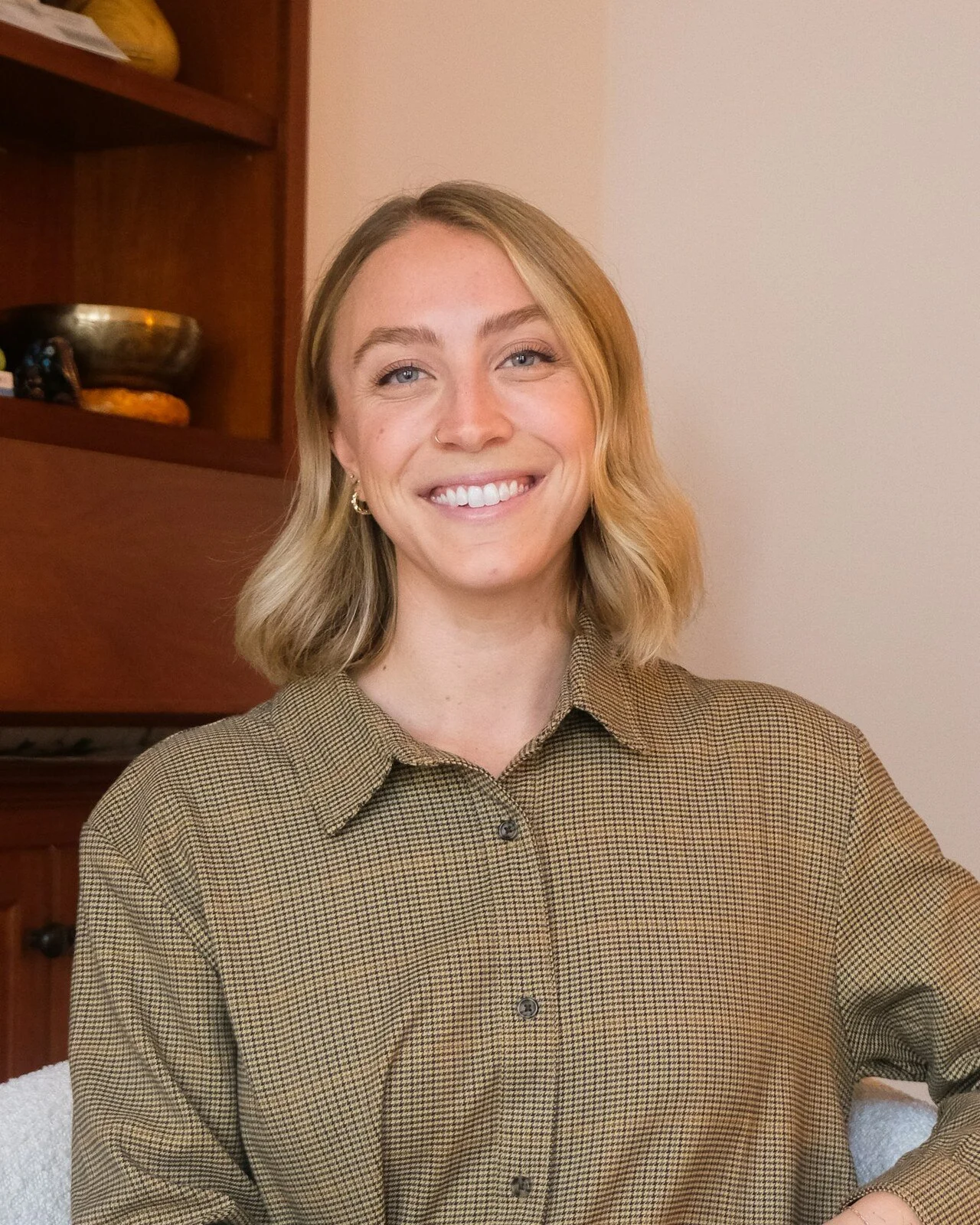 Annelise Hasselmann, associate marriage and family therapist, smiling in an olive shirt