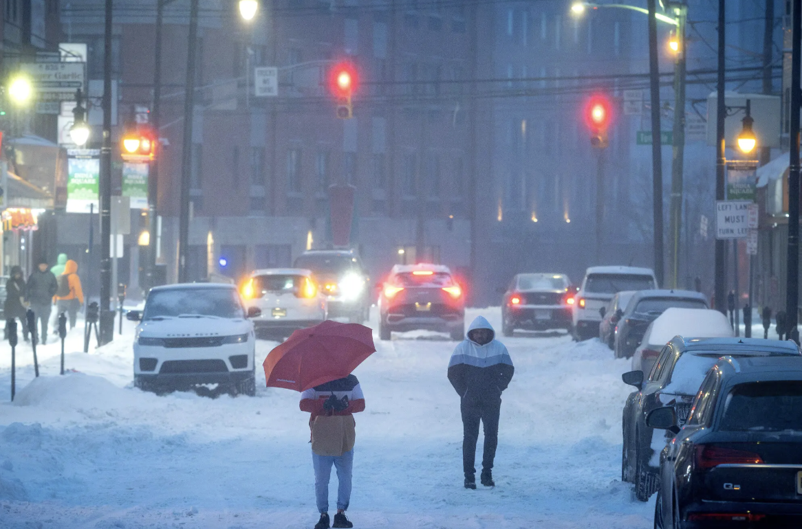 Pedestrians walked the snow-covered streets of Jersey City, N.J., during last month’s winter storm. Some scientists say there is a link between a warming planet and the recent frigid temperatures. Credit...Aristide Economopoulos for The New York Time