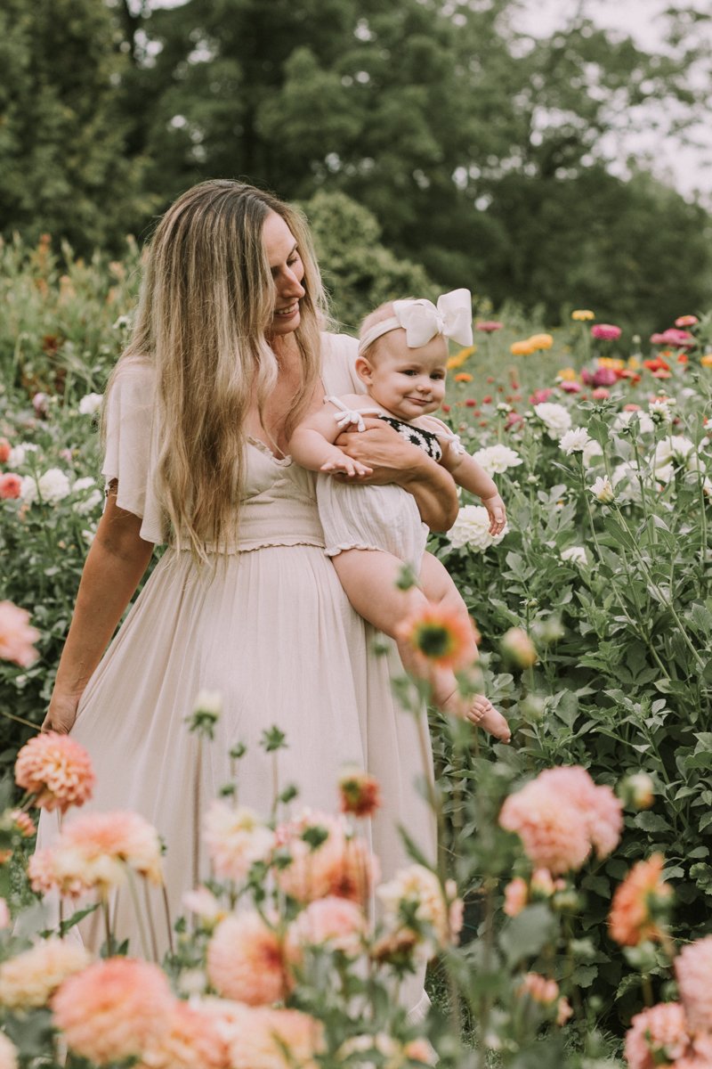 Beautiful mother and baby in a flower field.