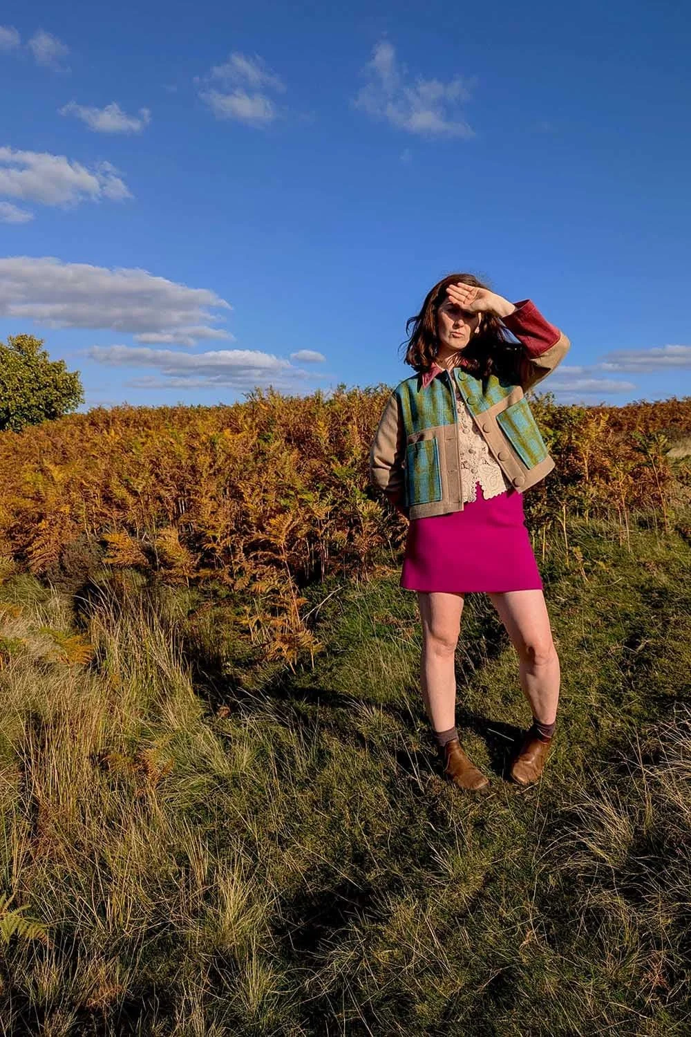 Woman wearing a unique wool chore jacket with playful colour block design, modelled in the North Yorkshire moors.