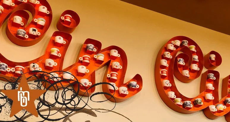 Decorative shelf spelling 'LOVE' with small teacups displayed.