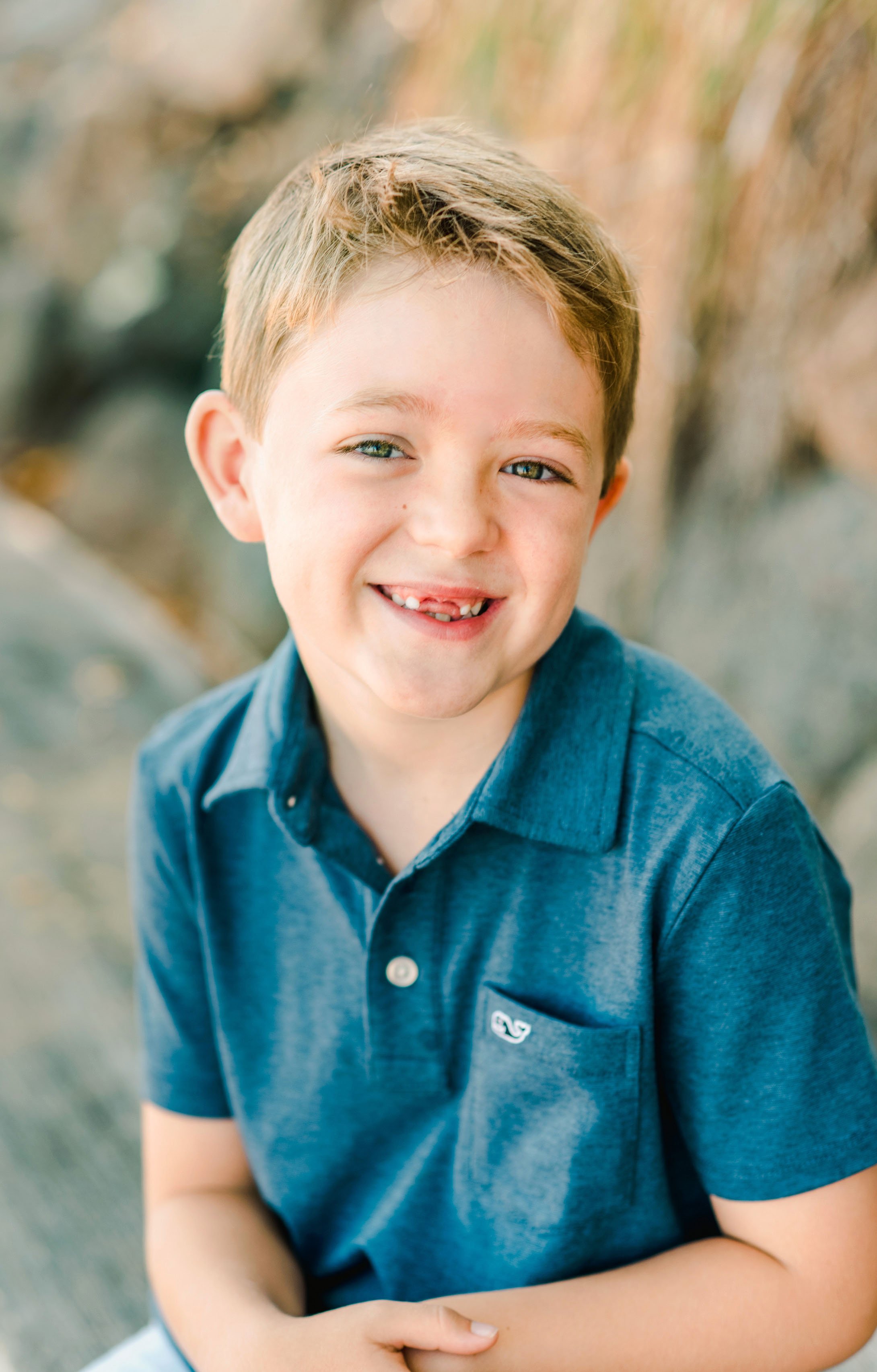 Smiling child in a blue shirt outdoors