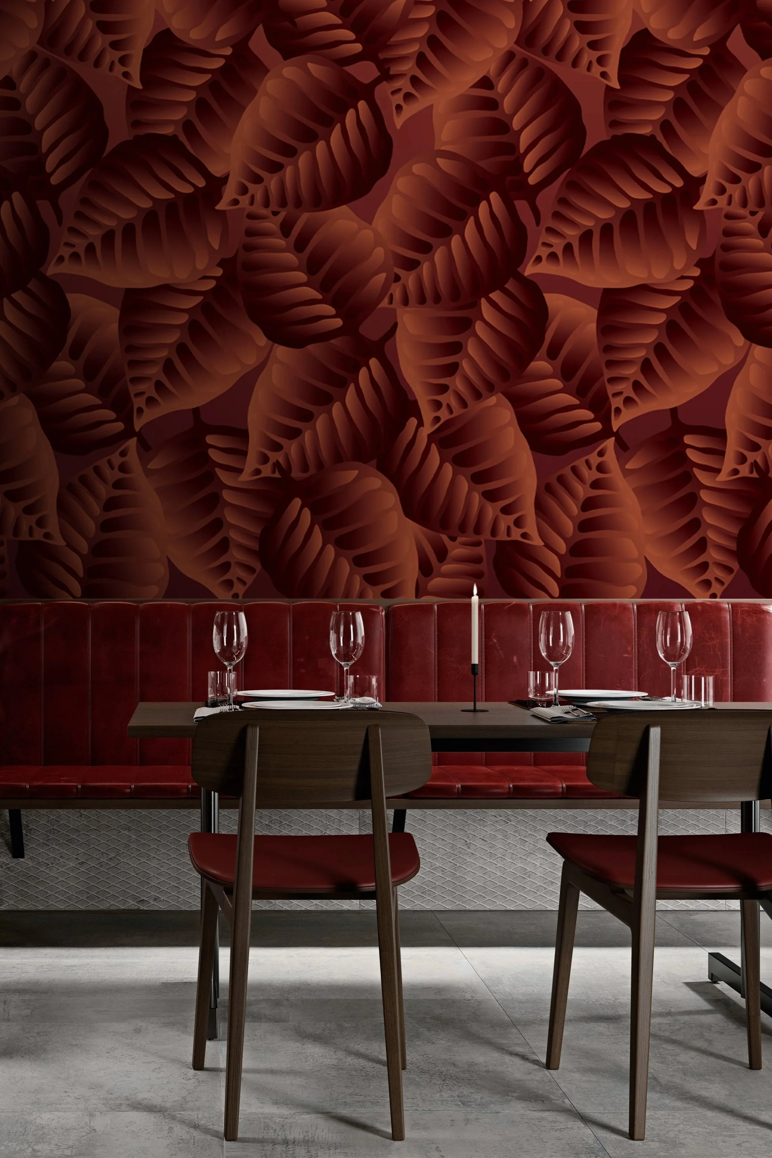 Modern dining area with a dark wooden table set with wine glasses, plates, and a candle, against a large wall with a red and brown leaf pattern.