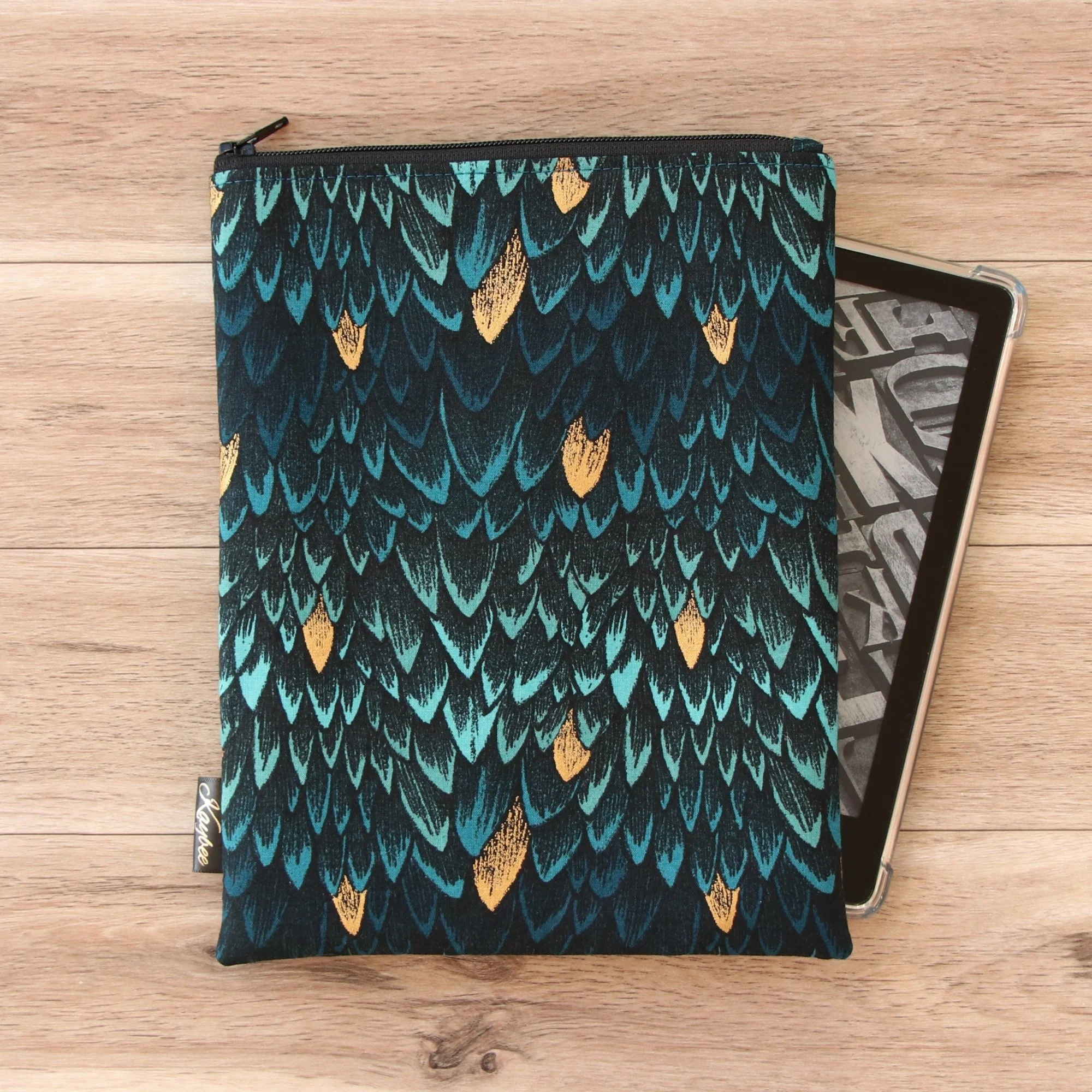 Handmade Kindle Sleeve in black and blue dragon scale fabric with a secure zip closure and soft padded lining.