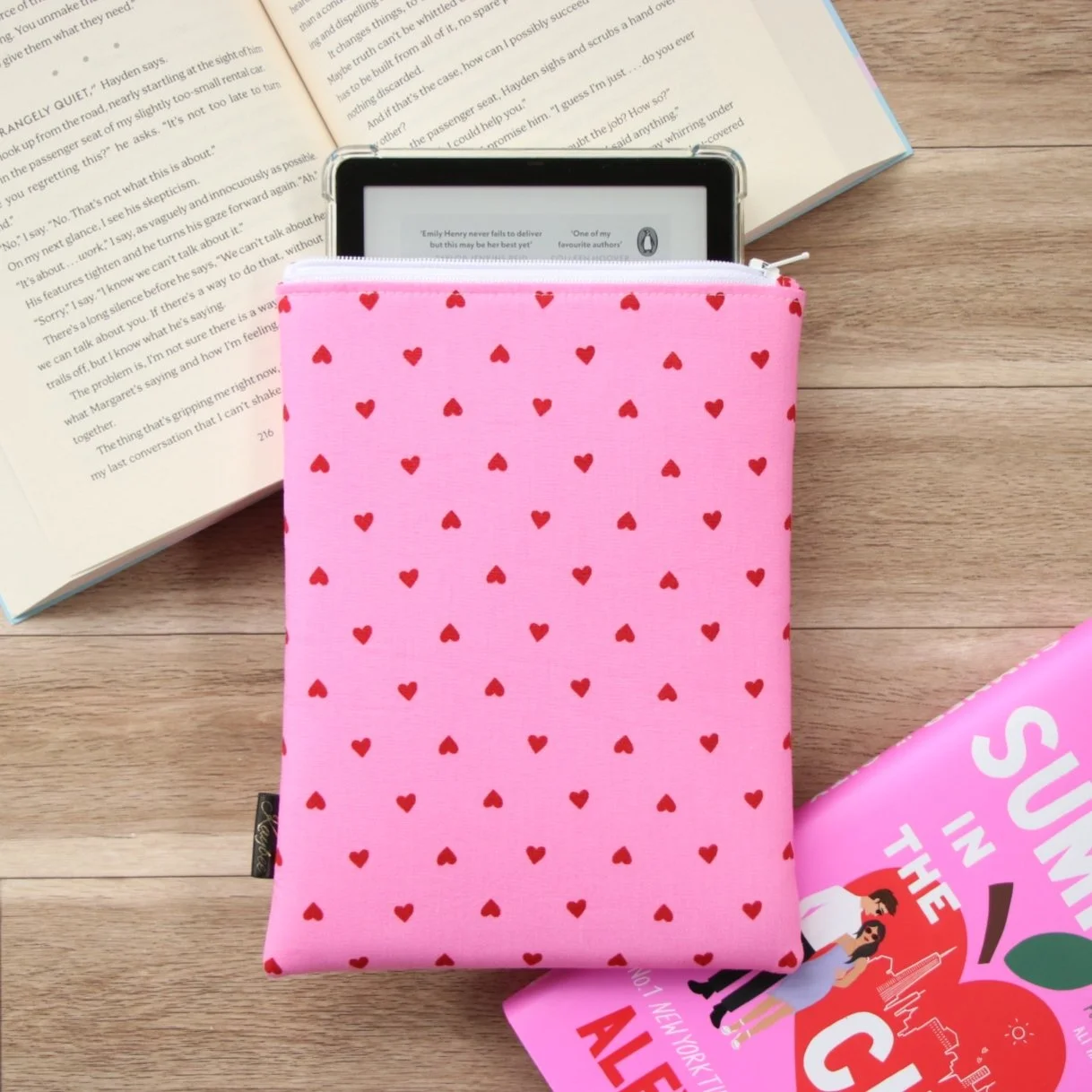 Handmade First Edition Kindle Sleeve with romance-inspired fabric beside book and reading accessories.
