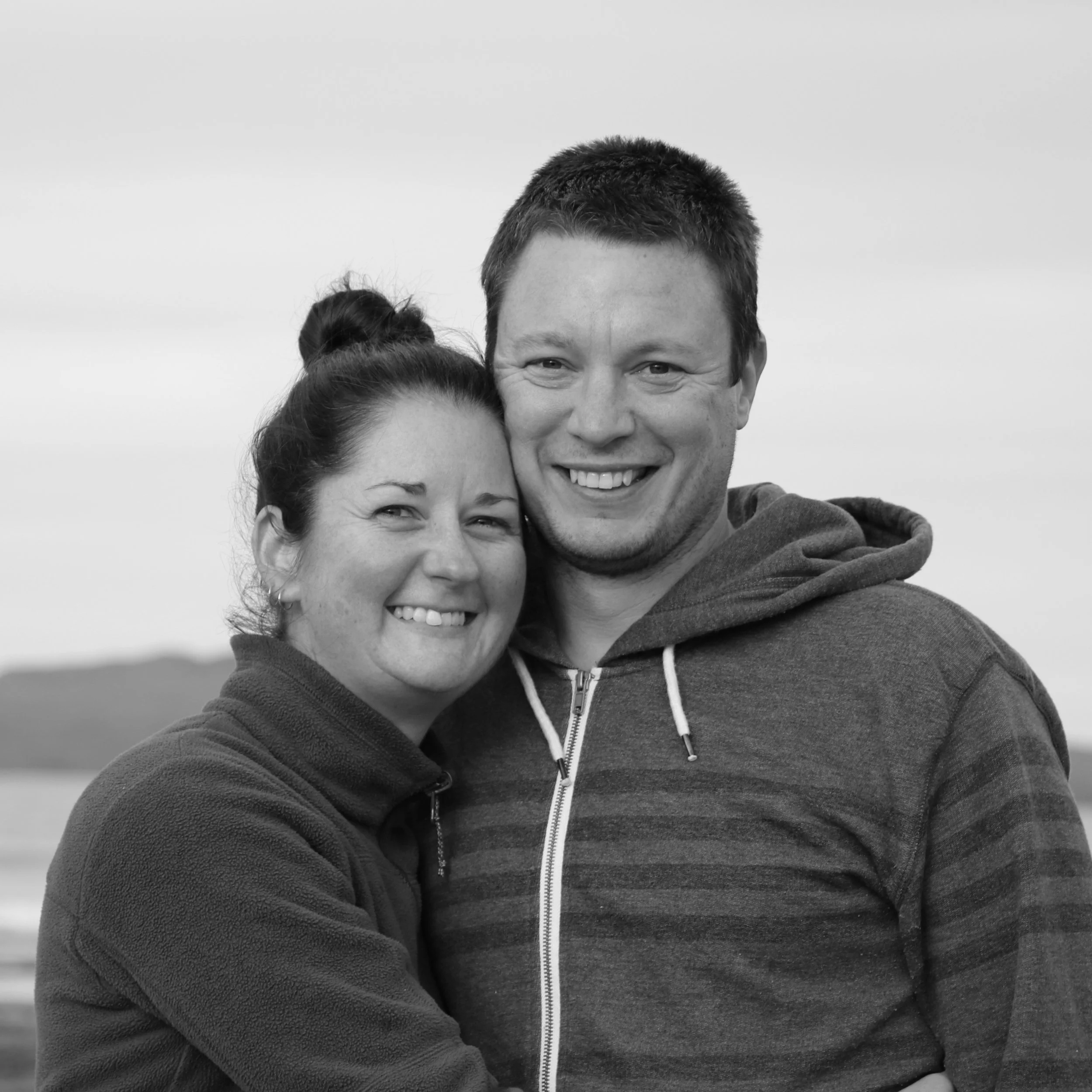 Photo of Karen and her husband at the beach with Rangitoto Island in the background