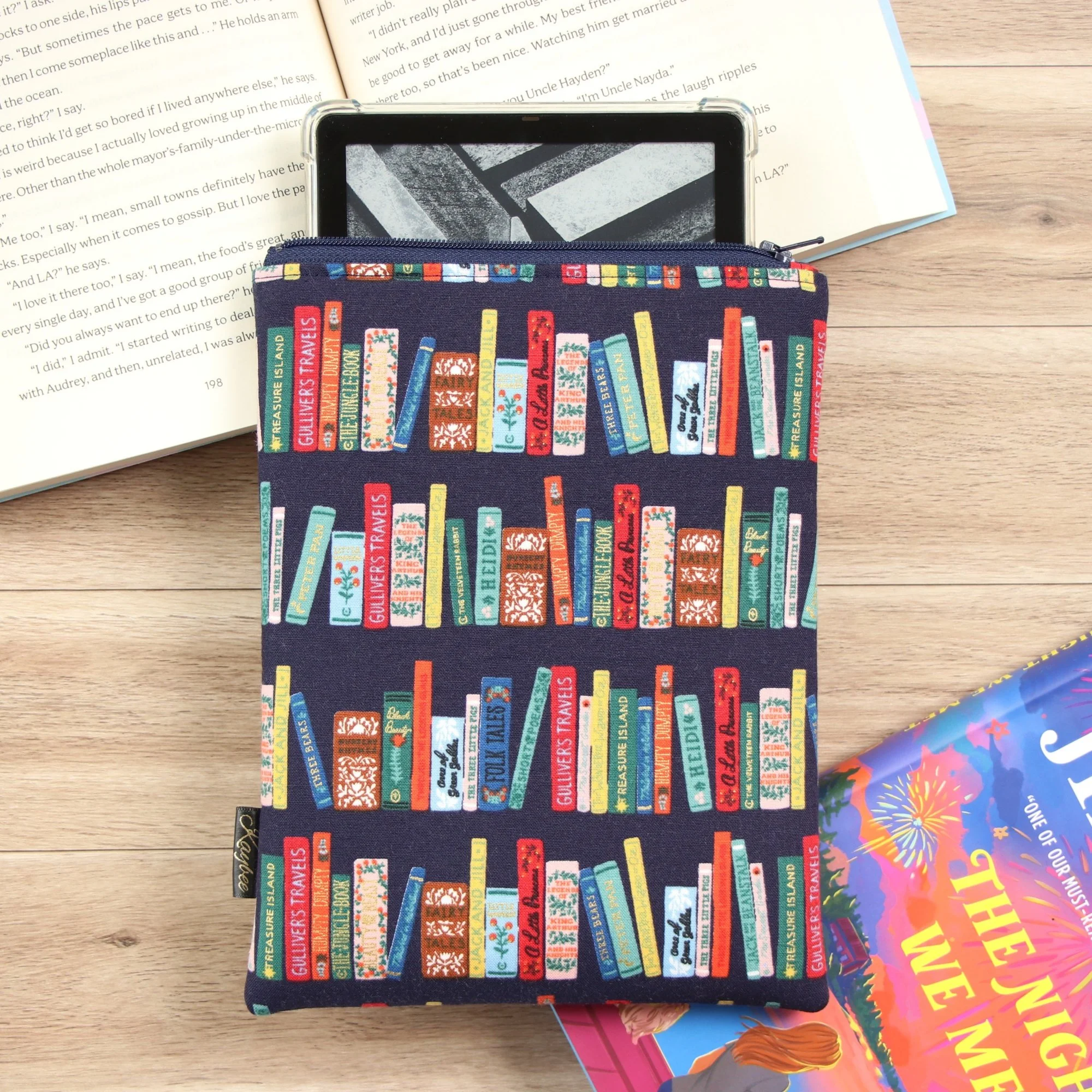 Handmade eReader sleeve made with Rifle Paper Co fabric with a Kindle and books.