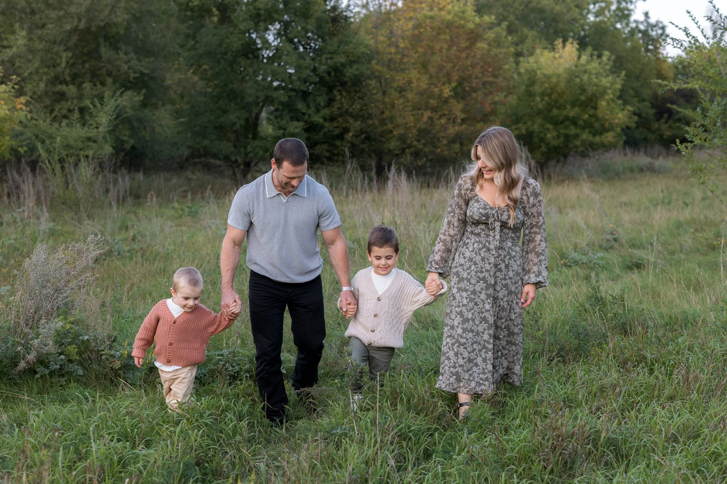 Family walking in field in the fall on Churchill Drive