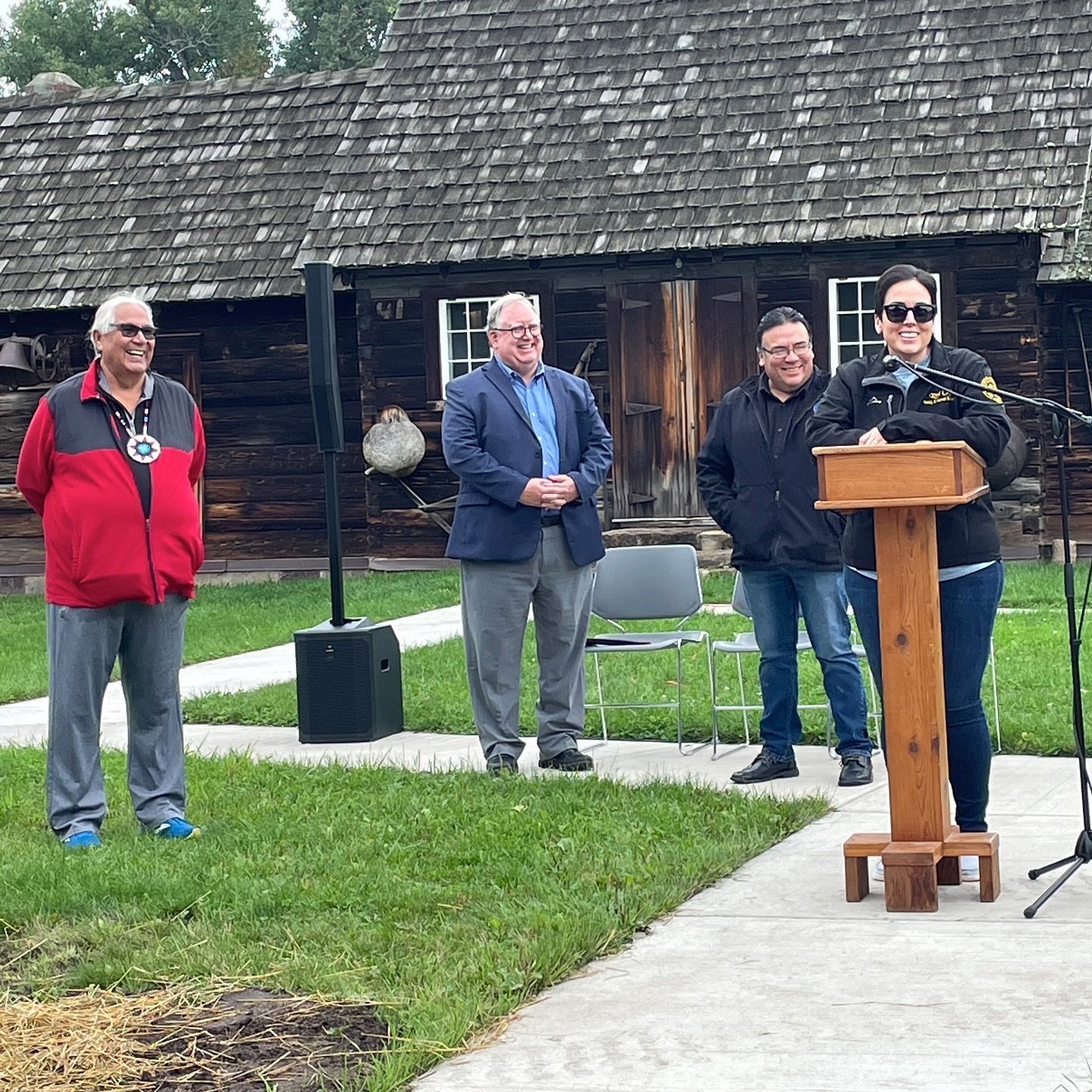 Red Cliff Tribal Chair Nicole Boyd speaking at the dedication of the new historic marker at the Madeline Island Museum while Bad River Tribal Chair Mike Wiggins Jr., Wisconsin Historical Society Executive Director Christian Overland and museum histor