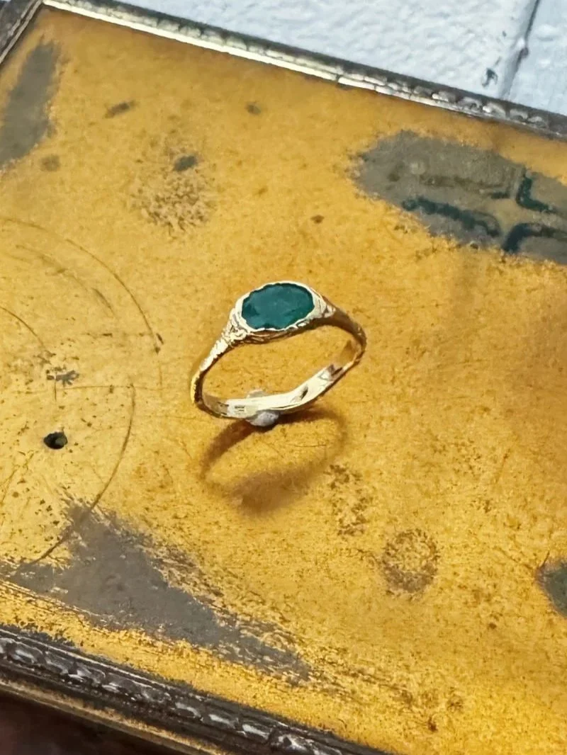 Organic gold ring with big emerald gemstone.