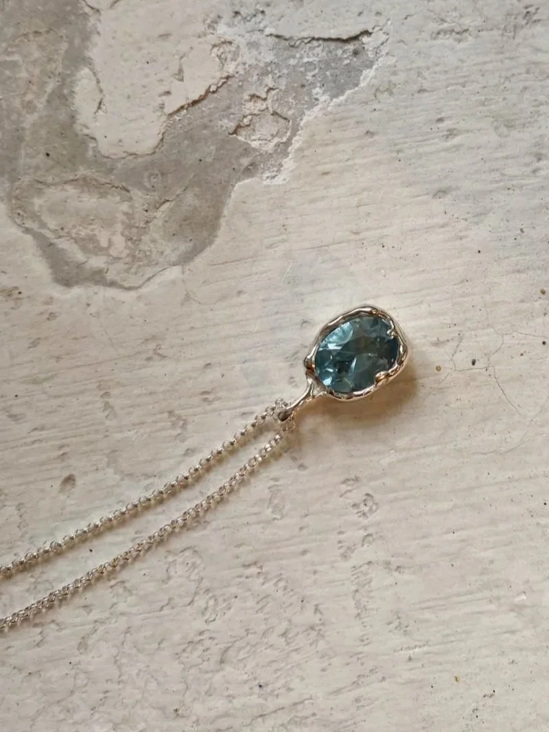 Modern necklace with a pendant featuring a topaz gemstone.