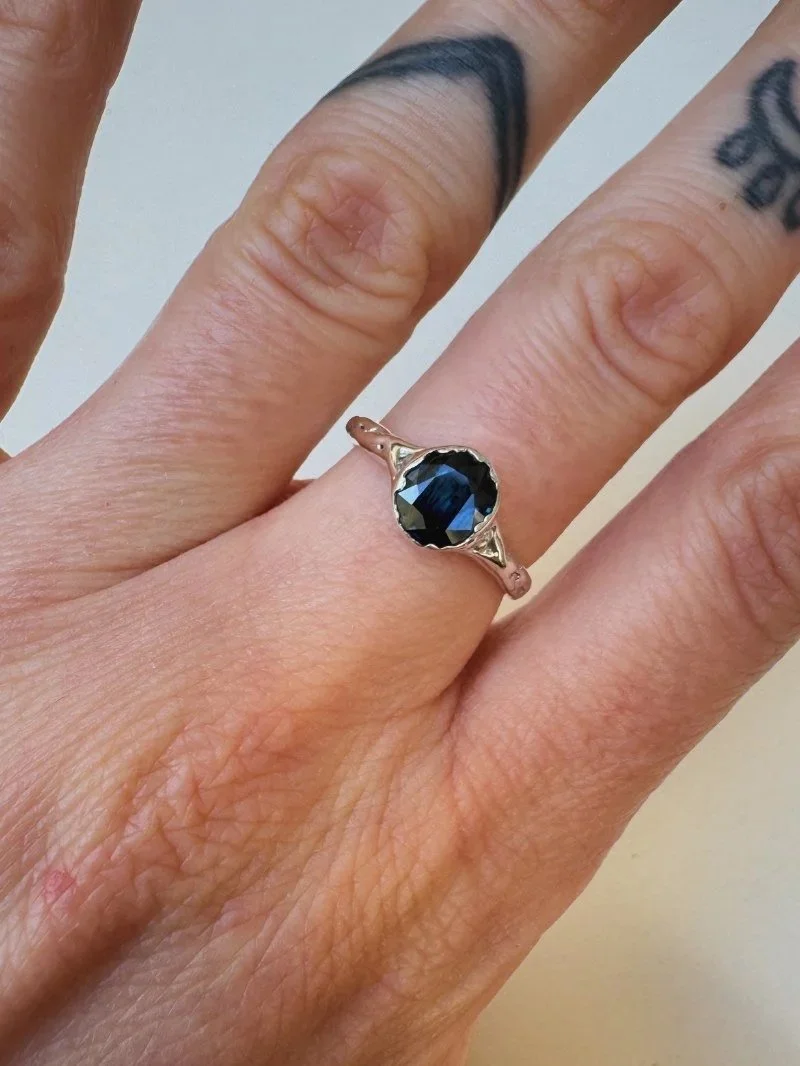 Organic gold ring with a blue sapphire gemstone detail