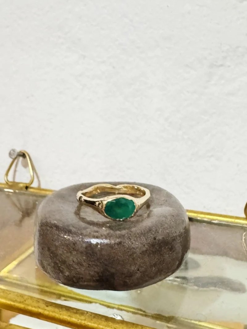 Alternative gold engagement ring with emerald gemstone