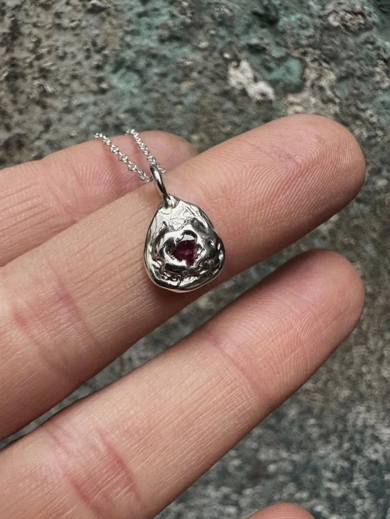 Unique ruby necklace in solid 925 sterling silver or gold, with a cast-in-place gemstone, raw texture and modern artisan design.