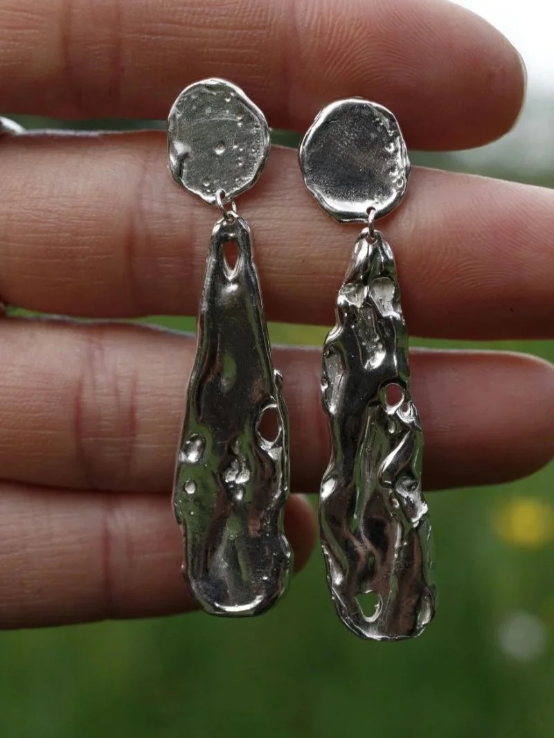 Modern sculptural silver earrings with an organic lunar texture, handmade from recycled silver.