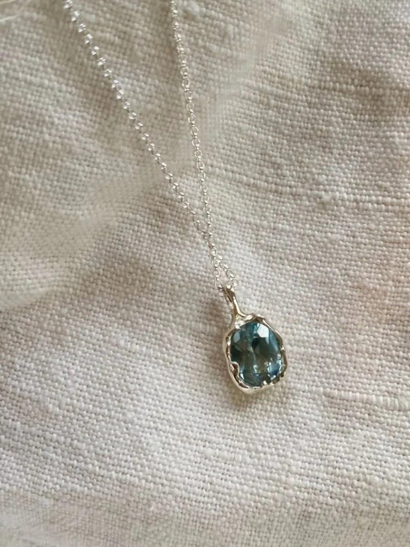 Modern and different organically shaped silver pendant with topaz gemstone.