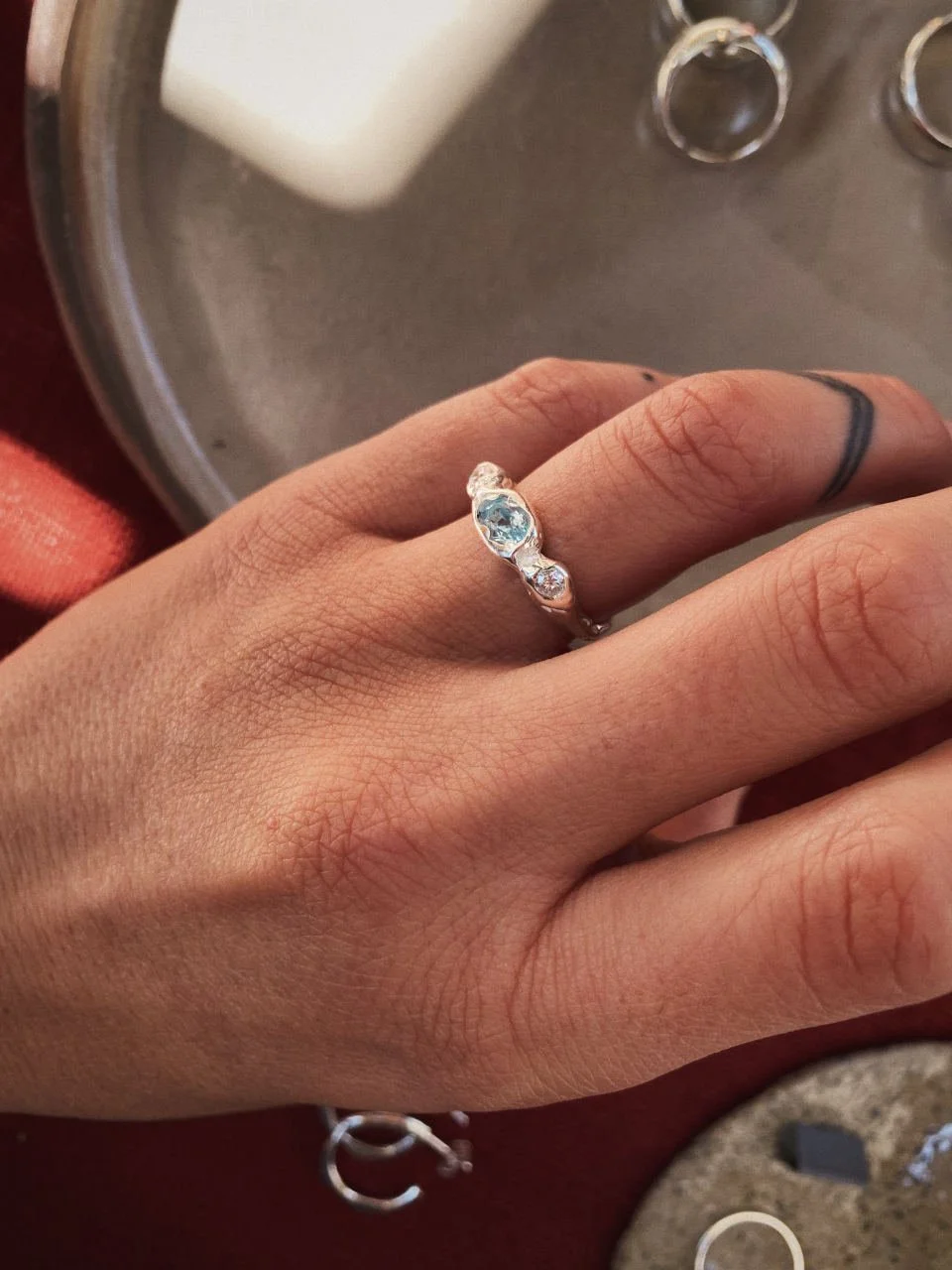Organic topaz and diamond ring handcrafted in recycled sterling silver or gold, featuring a light blue stone and sculptural design.
