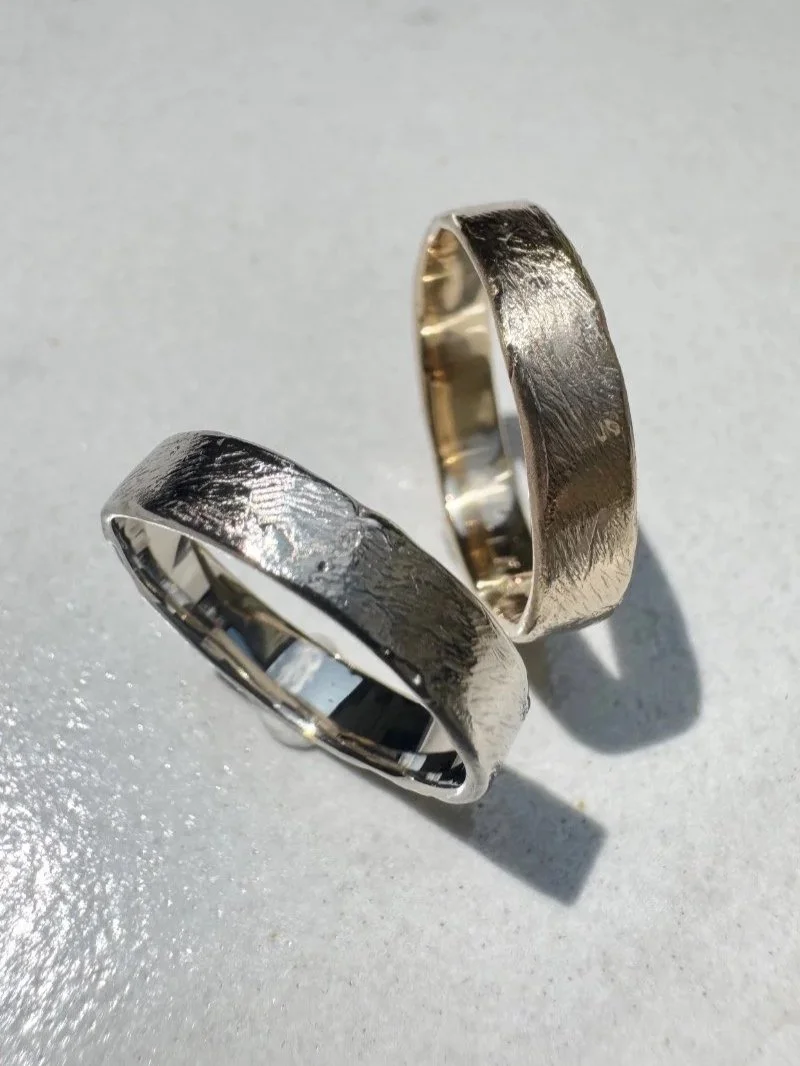 Minimalist gold wedding bands with delicate texture, handcrafted fine jewellery for brides and grooms