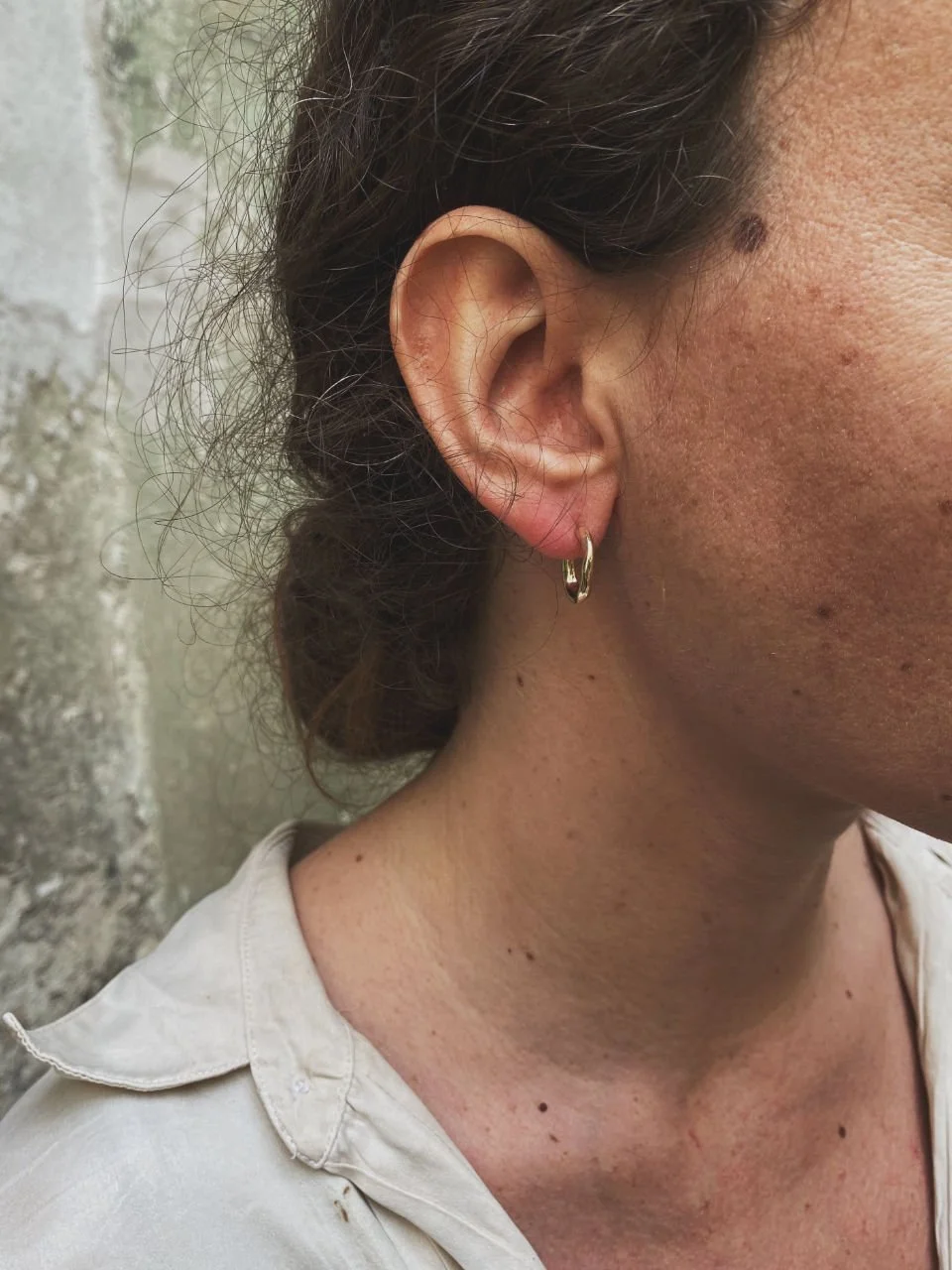 Organic mini gold earrings handmade with raw sculptural curves for lovers of modern, minimalist jewellery.