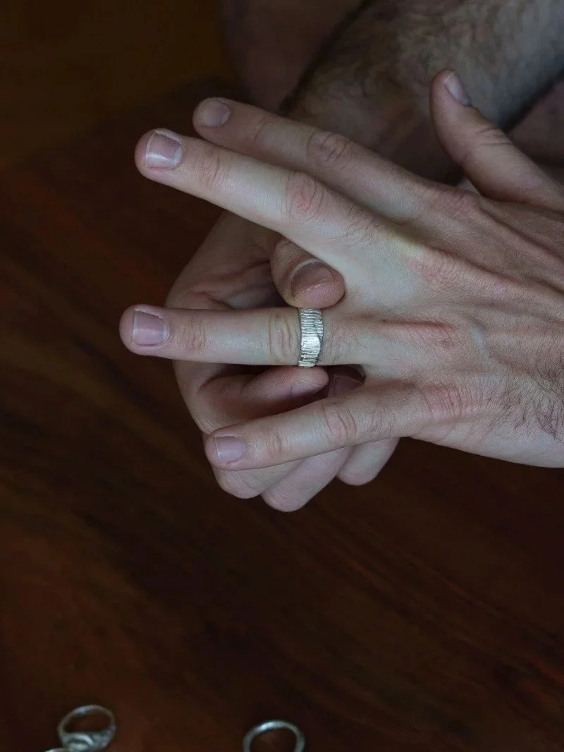 Bold men’s statement ring in recycled sterling silver with an irregular sculptural shape, engraved linear texture and raw modern design.