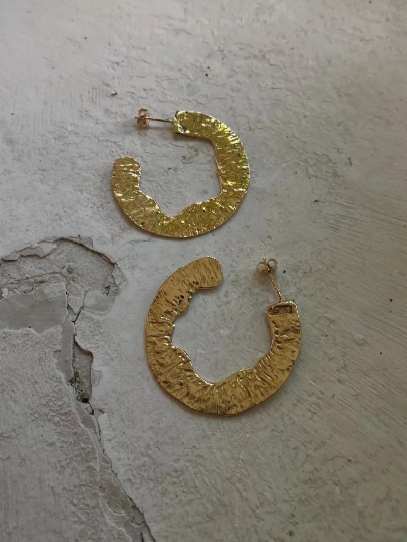 Bold round earrings in recycled gold with a sculptural hammered surface, handcrafted for elegant summer and occasion wear.