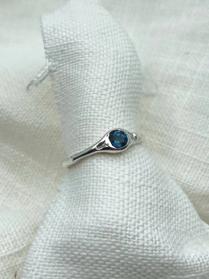 Handmade deep blue topaz ring in recycled 925 sterling silver with an organic band, raw texture and wabi-sabi design.