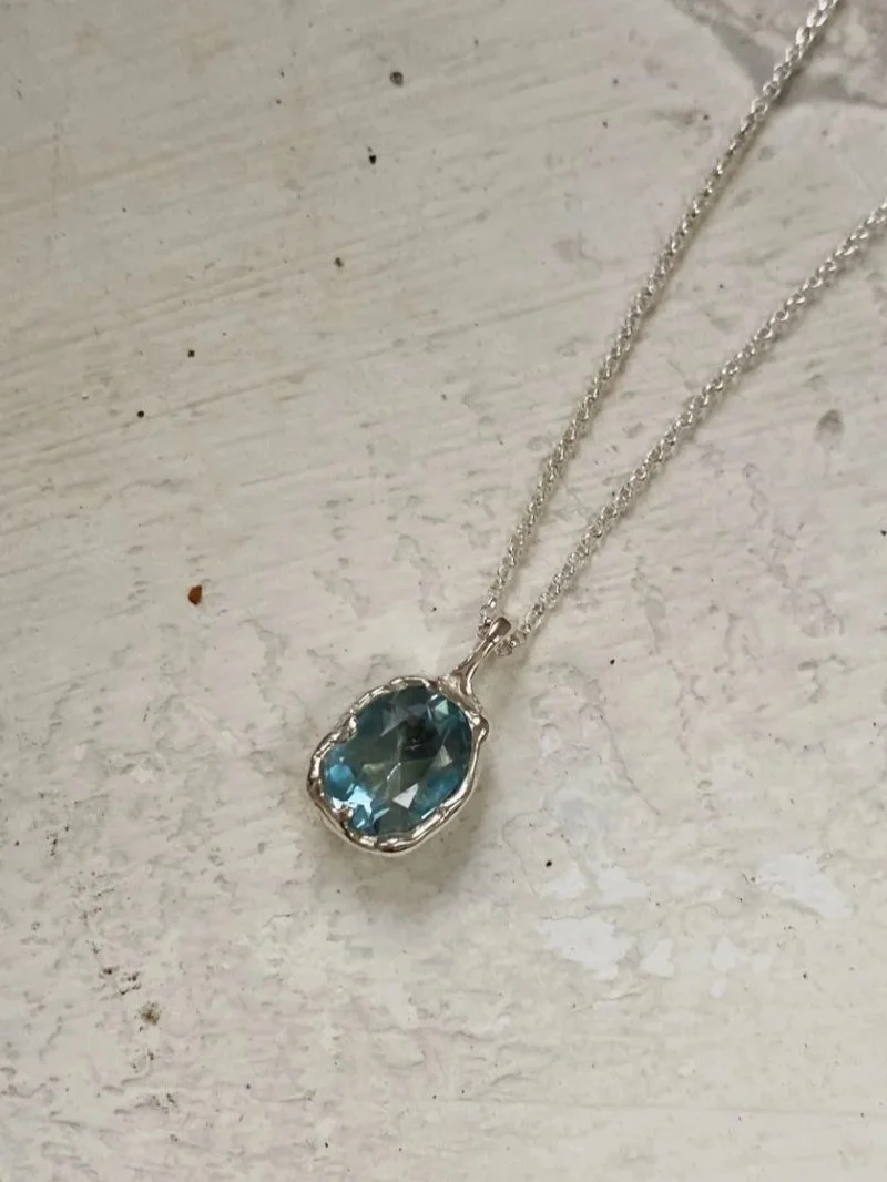 Modern necklace with a gemstone pendant.