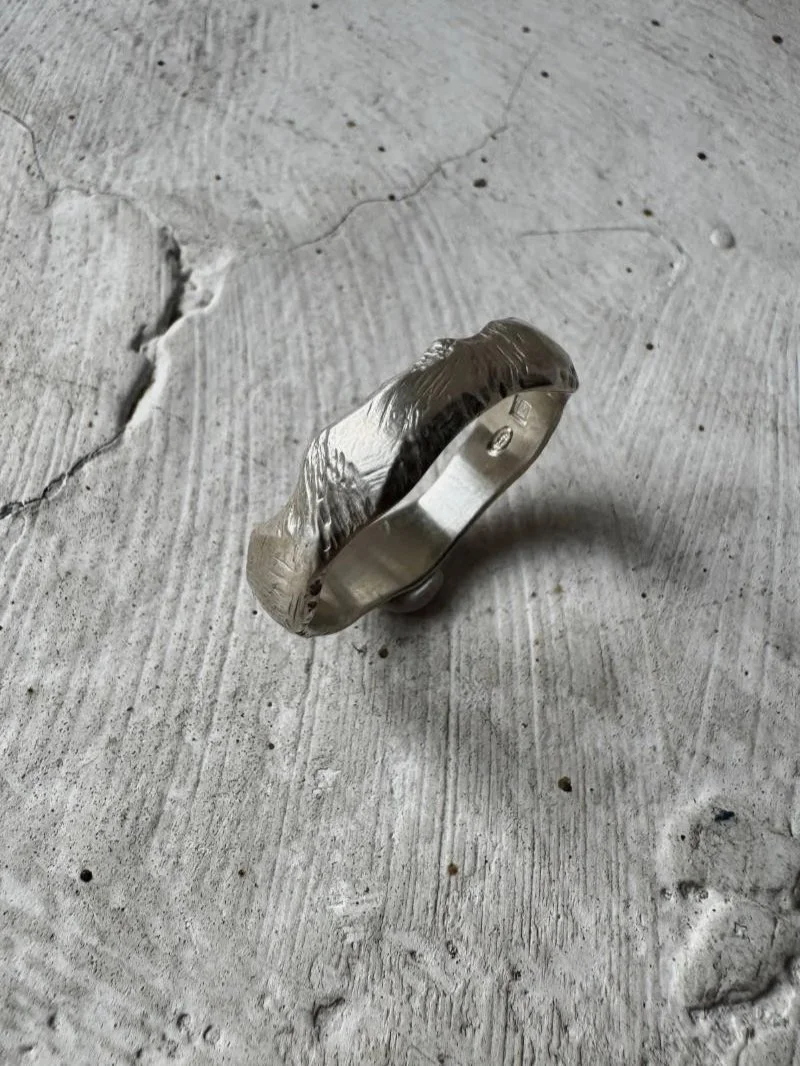 Organic sterling silver men’s ring with a bold wide band and textured finish, ideal as a modern wedding ring or everyday band.