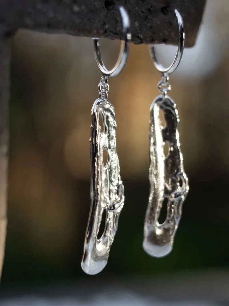 Crafted by hand from recycled sterling silver, Liquid earrings are inspired by the fluid texture of molten metal and finished with a strong polished shine.