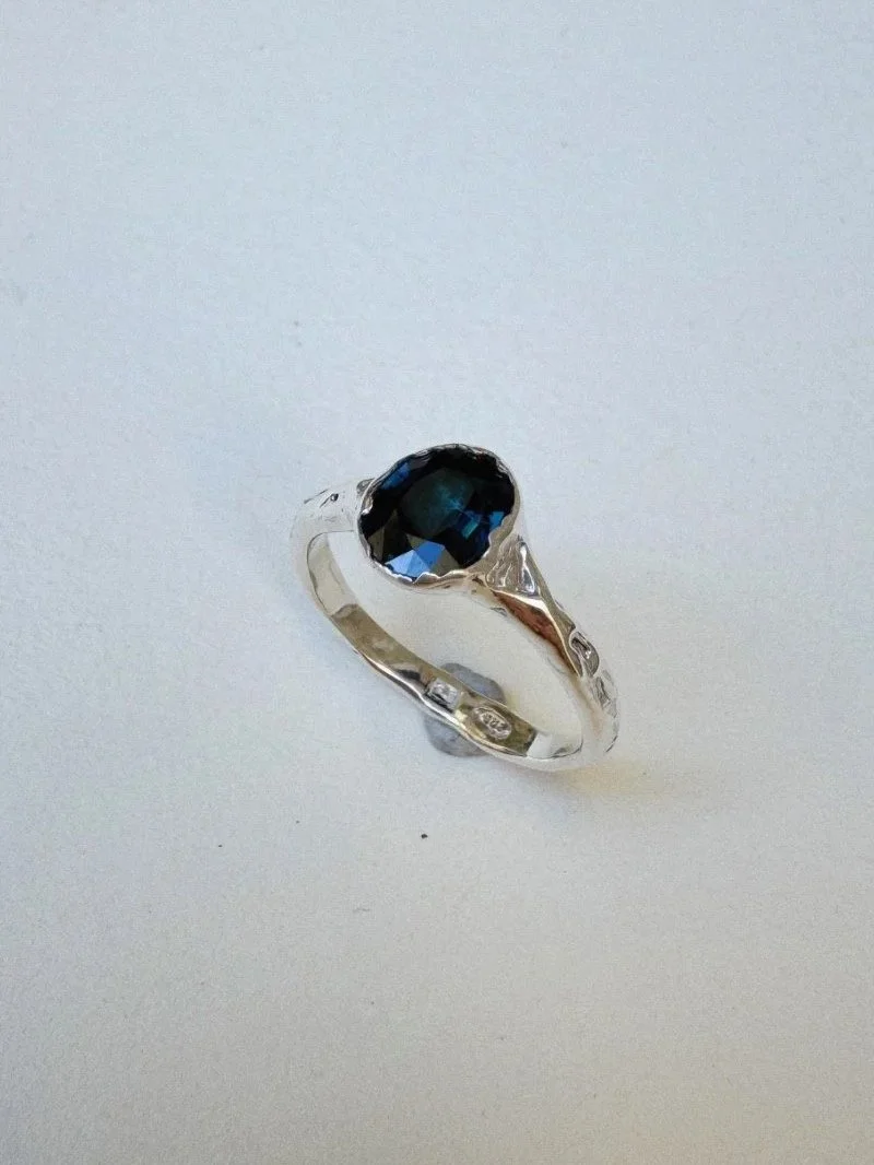 Alternative silver engagement ring with deep blue sapphire