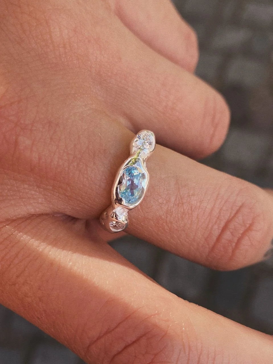 Light blue topaz ring with two small diamonds, handmade in recycled 925 sterling silver for lovers of raw modern jewellery.
