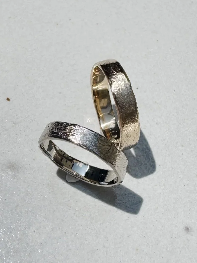 Handmade classic wedding bands in gold with refined soft texture and modern minimal elegance