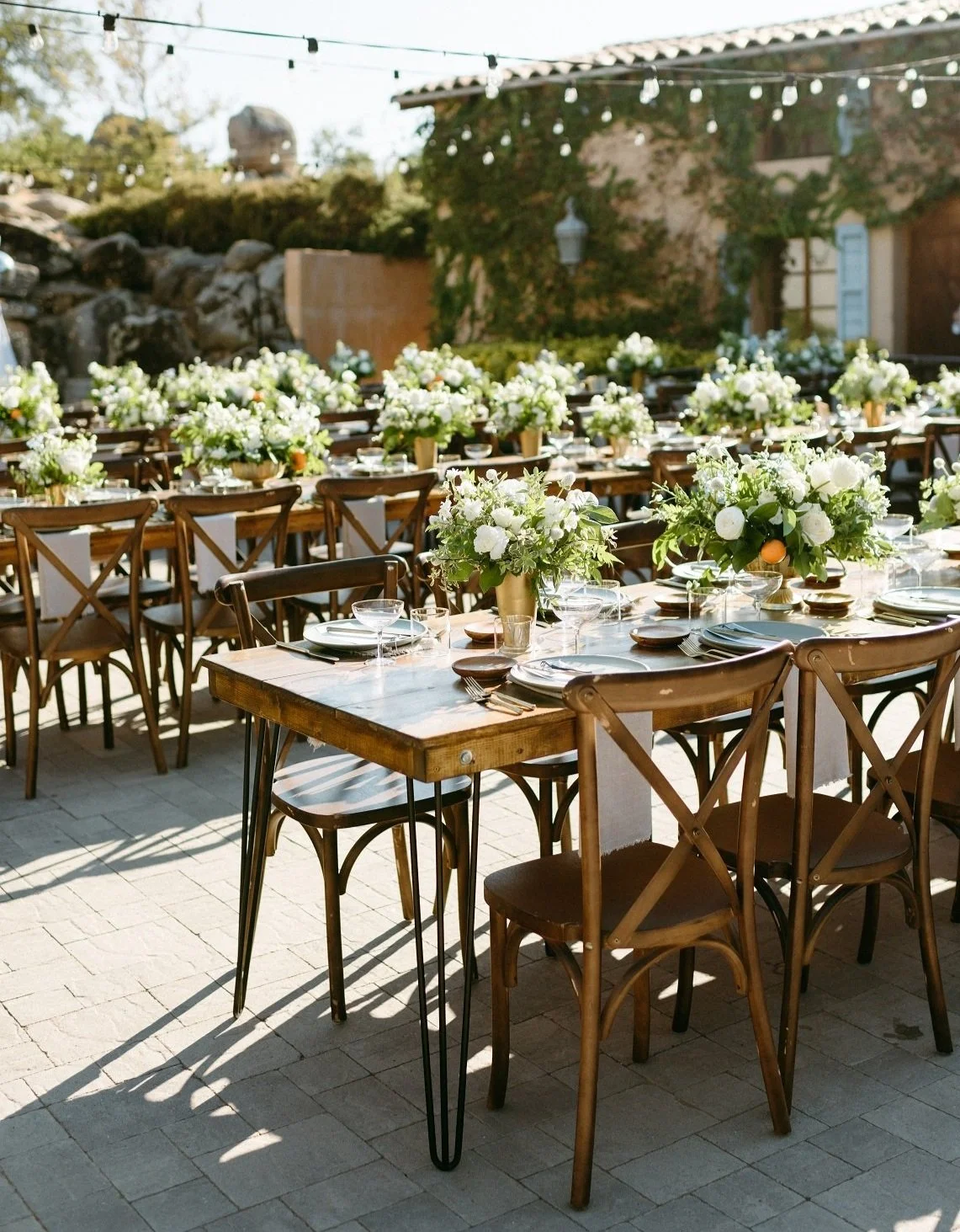 A gorgeous row of tables set up and decorated for an event on the outdoor patio at Milagro in Ramona, California. 