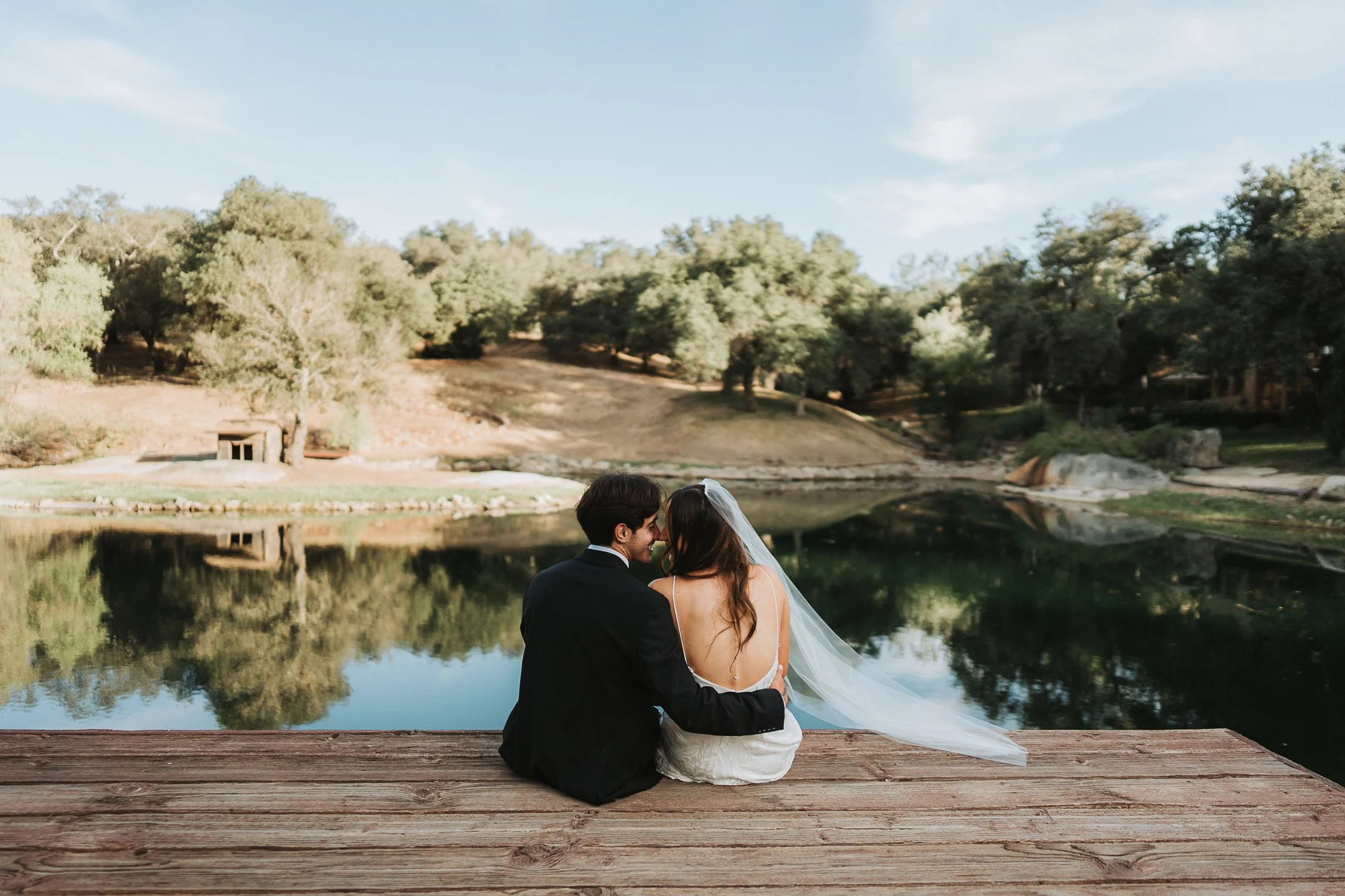 A married couple sitting on the dock overlooking the gorgeous lake at Milagro in Ramona, California.