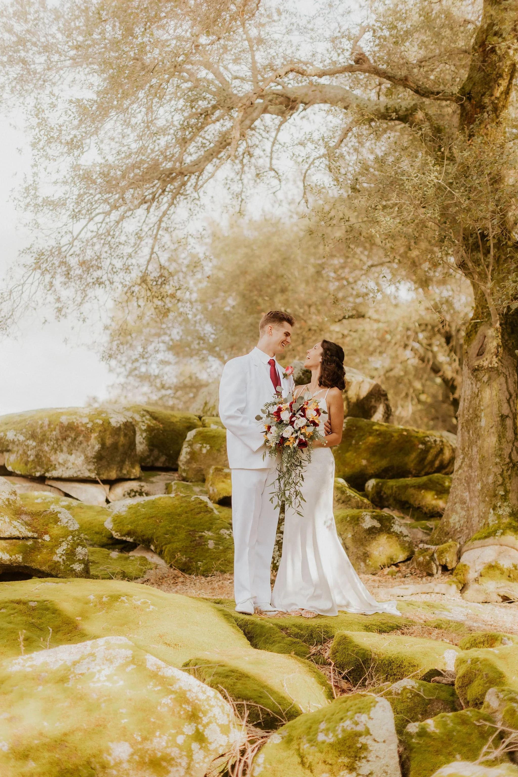 A couple standing in a beautiful garden on their wedding day at Milagro in Ramona, California.