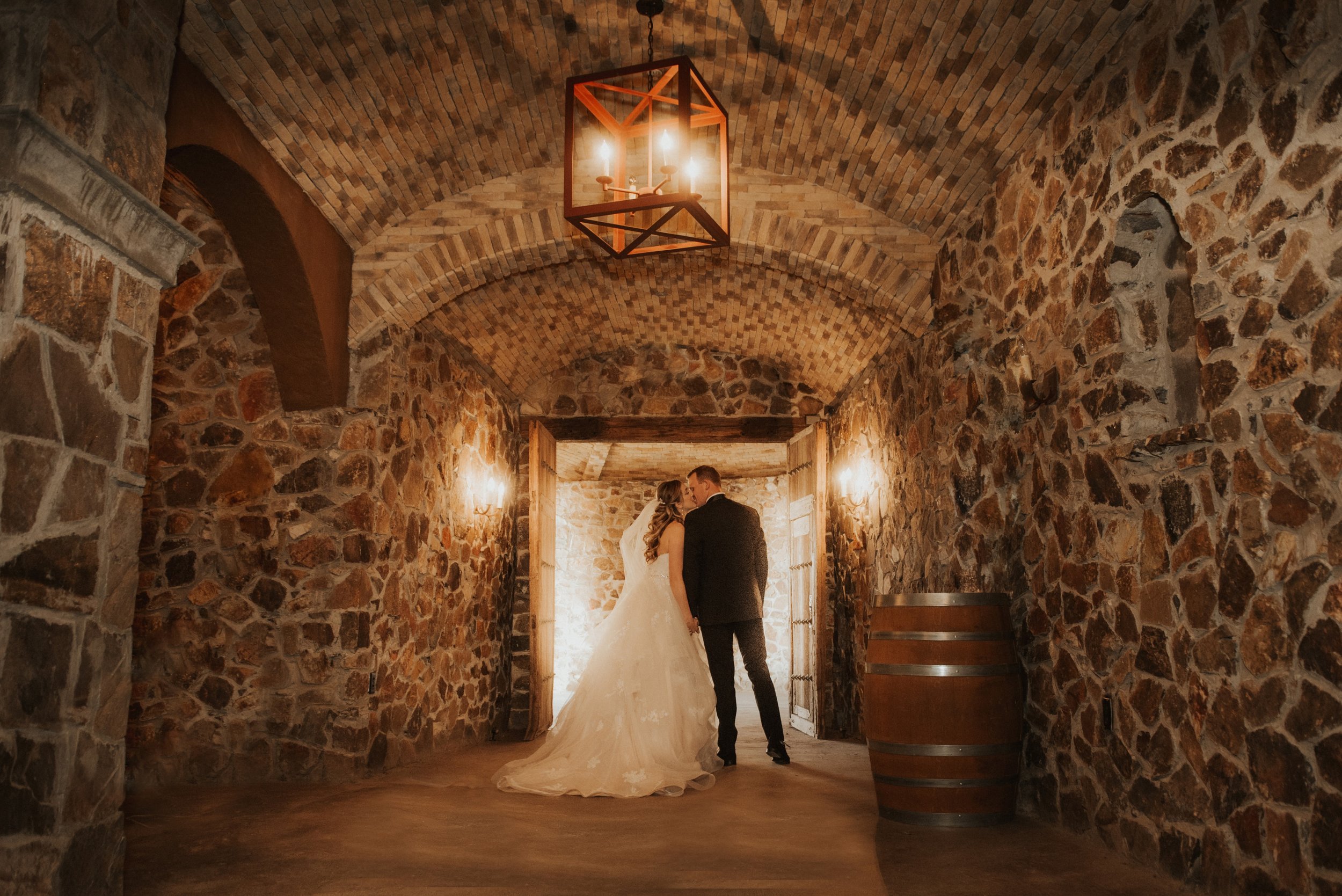 A married couple kissing in the entryway of the Wine Cave and Groom's Suite at Milagro in Ramona, California. 