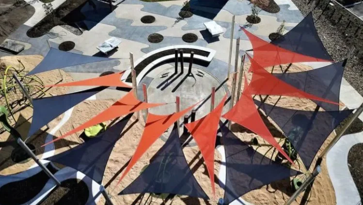 A colorful outdoor playground with shade sails in navy and orange, awning, shade canopy. Commercial shade sails. commercial shade awning