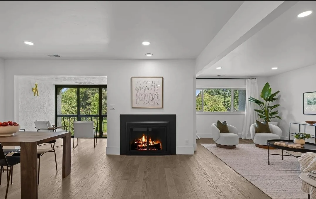 Interior view of a room under construction with multiple large windows, a door, and construction tools and materials scattered around.