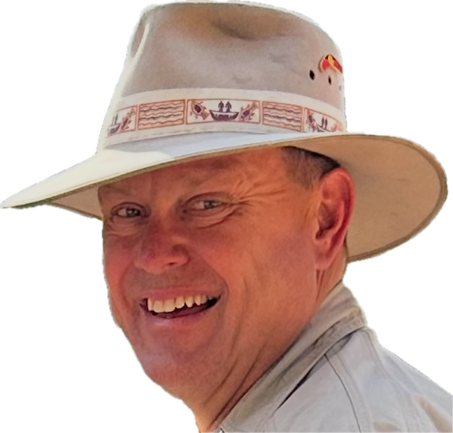 A smiling man wearing a beige wide-brimmed hat and a light-colored shirt.