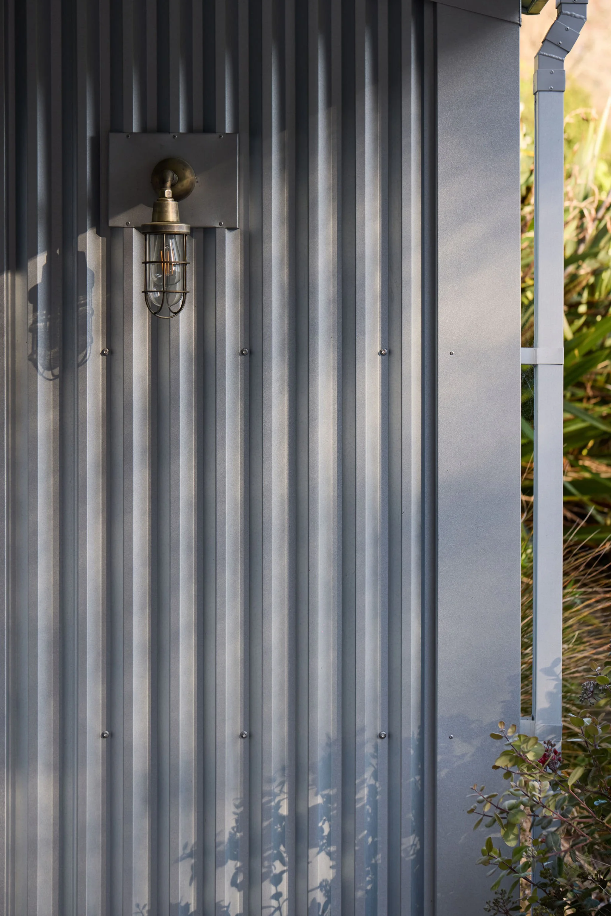 Close-up of a gray metal outdoor wall with a vintage-style outdoor light fixture.