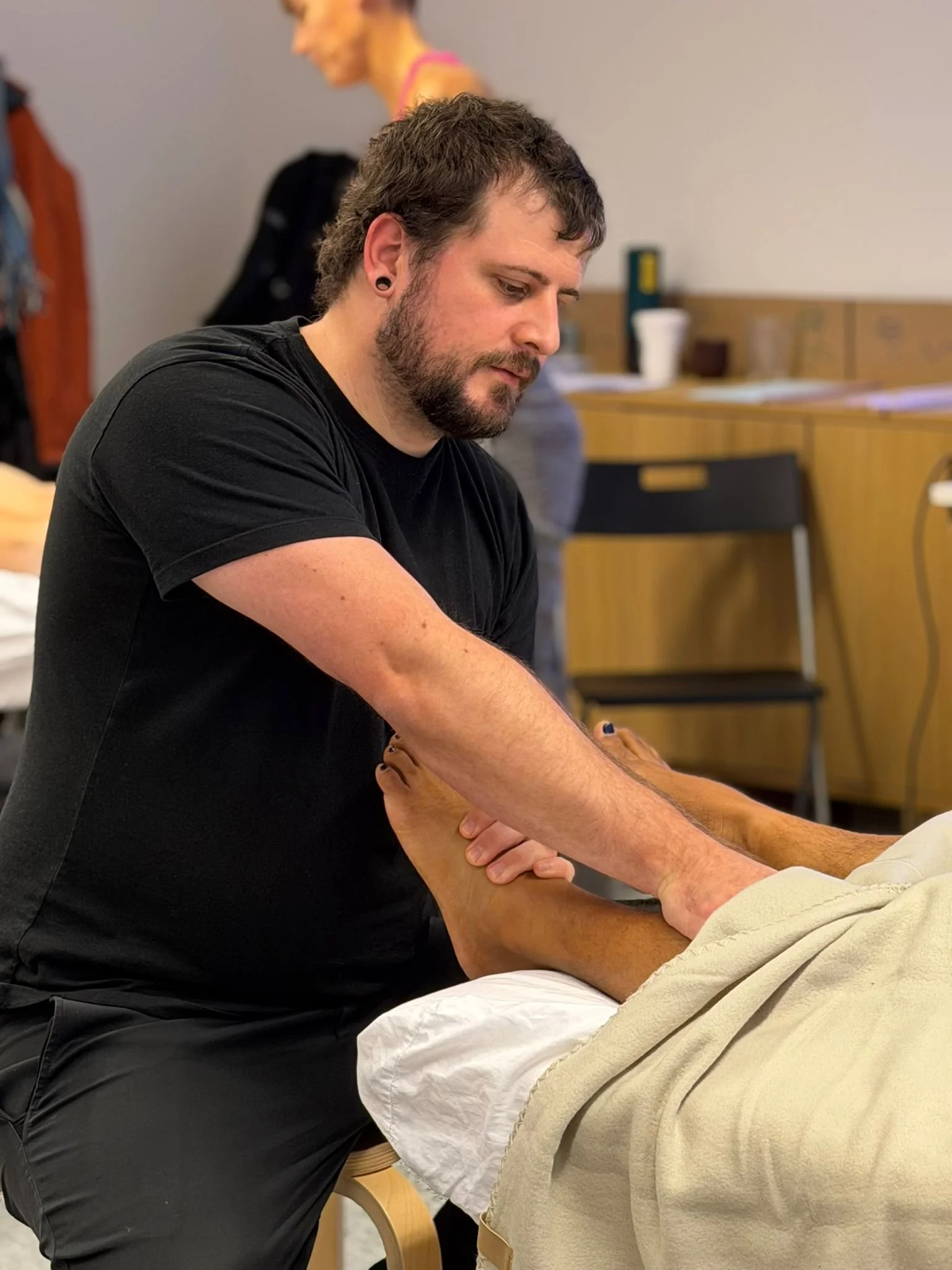 Parker Loesch applying Structural Bodywork to a clients lower leg and feet
