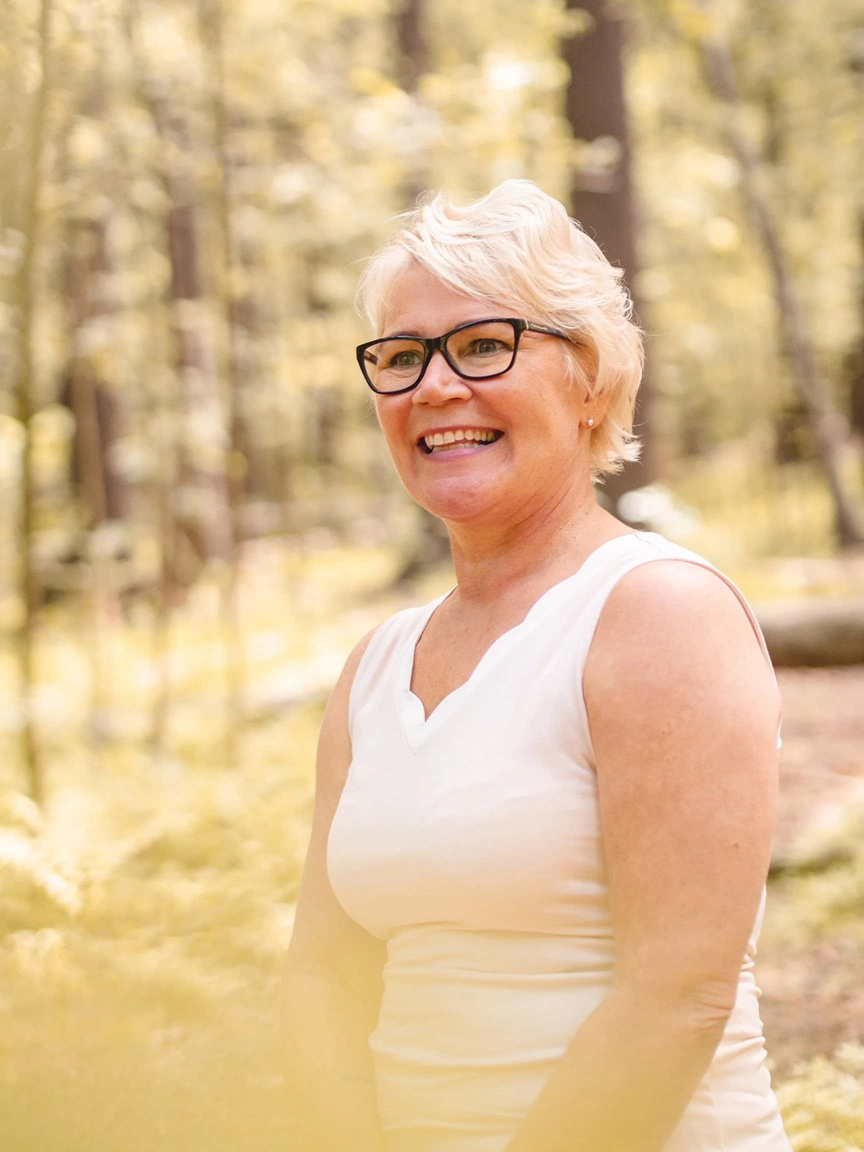 Kirsi Penttinen hymyilee iloisesti katsellen kaukaisuuteen.
