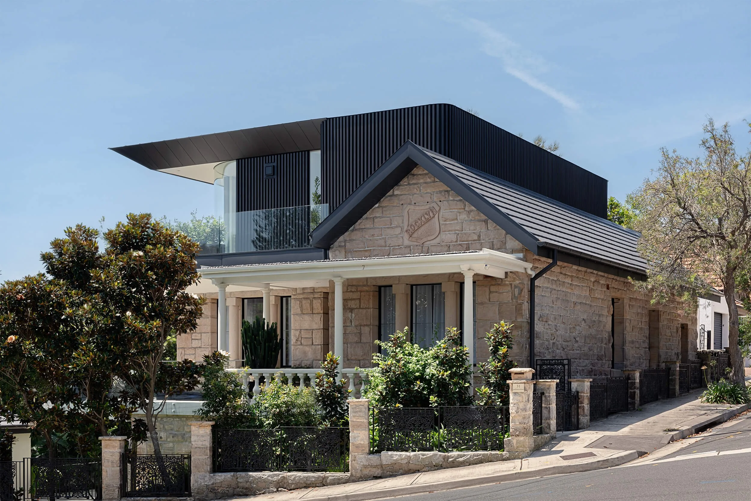 Stonemasons house featuring a restored heritage sandstone facade integrated with a modern black timber second-story addition in NSW, documented by Light & Lines Architectural Photo & Cinema