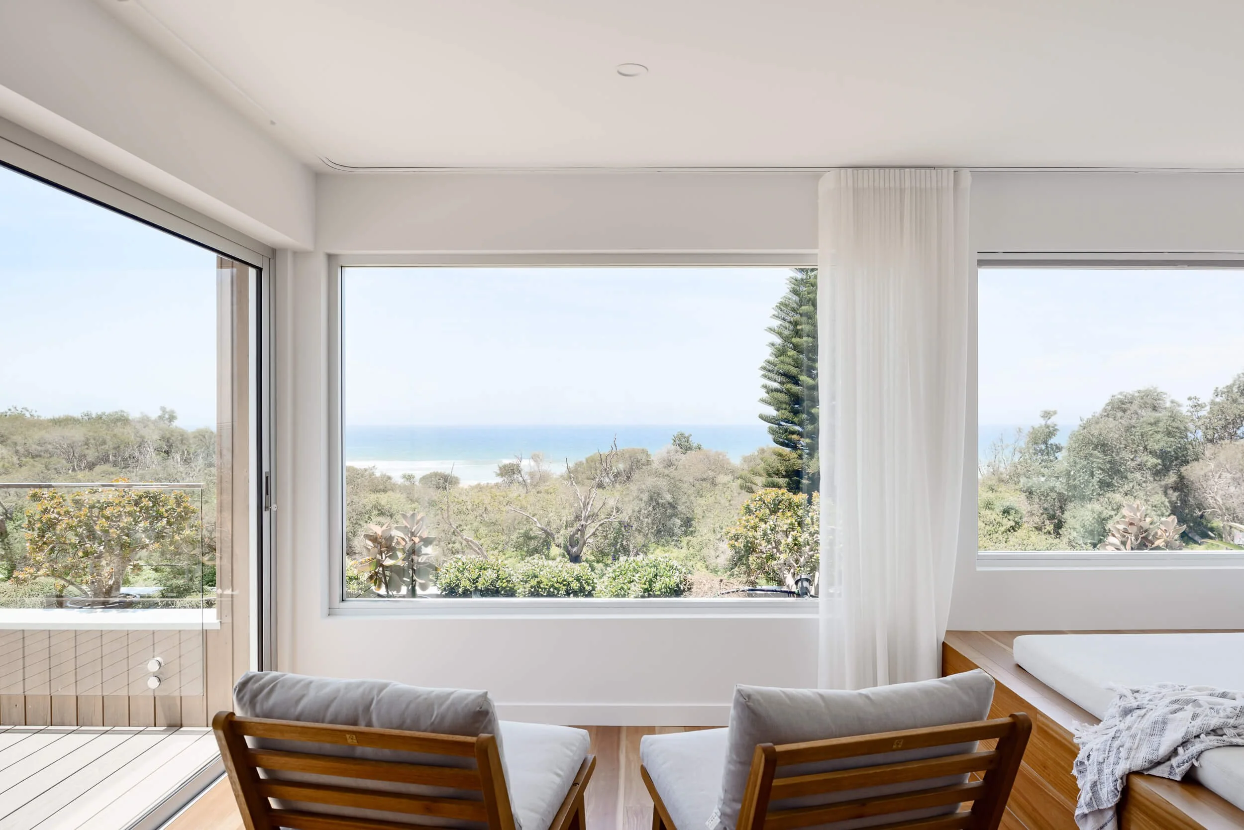 Large picture window with coastal views and built-in timber window seat at Pacific 5. Premium architectural photography and film documenting true materiality and craftsmanship for Master Builders, architects and designers in Regional NSW.