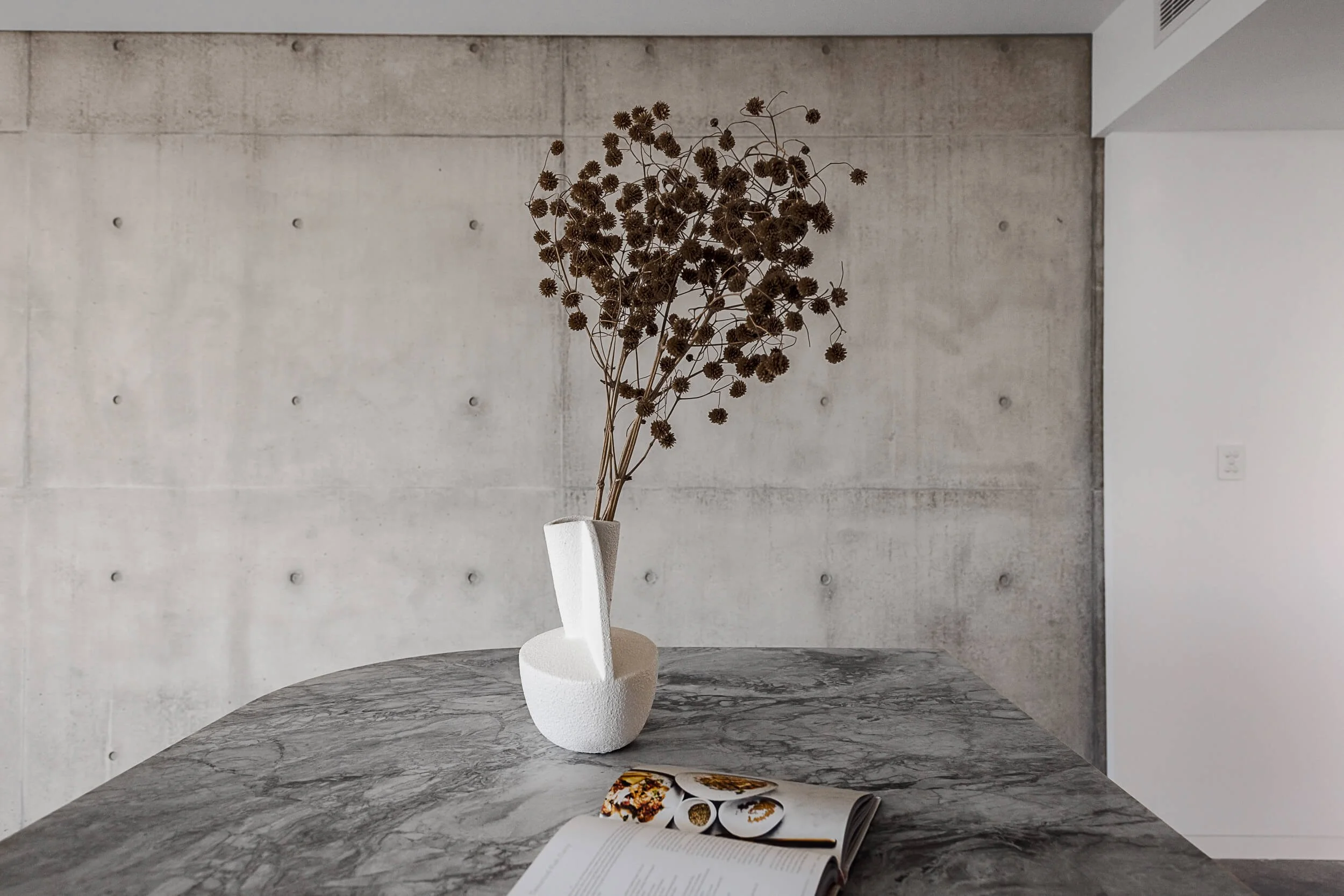 Premium architectural photography and film documenting true materiality and craftsmanship—highlighting exposed off-form concrete tie-holes, natural marble veining, and refined interior styling—for Master Builders and designers in Regional NSW.