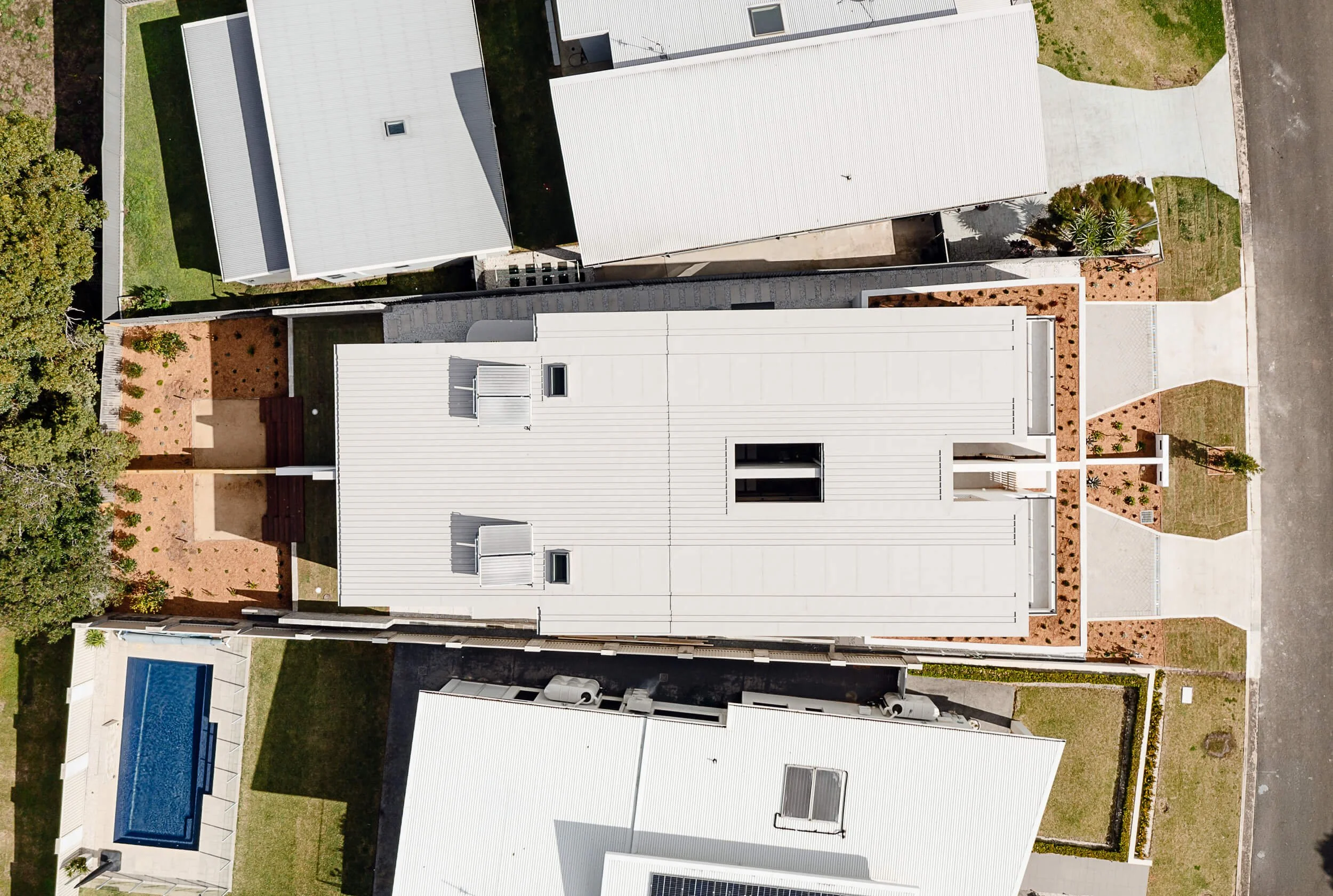 Aerial top-down architectural view of O'Brien Duplex Bulli showing metal standing seam roof, central courtyard void, and site planning by Kibbin Design and SLD Projects
